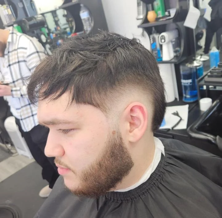 Side view of a men's textured crop with a low taper and short beard, cut by Ben Santiago at Gem City Barbers in Erie, PA.