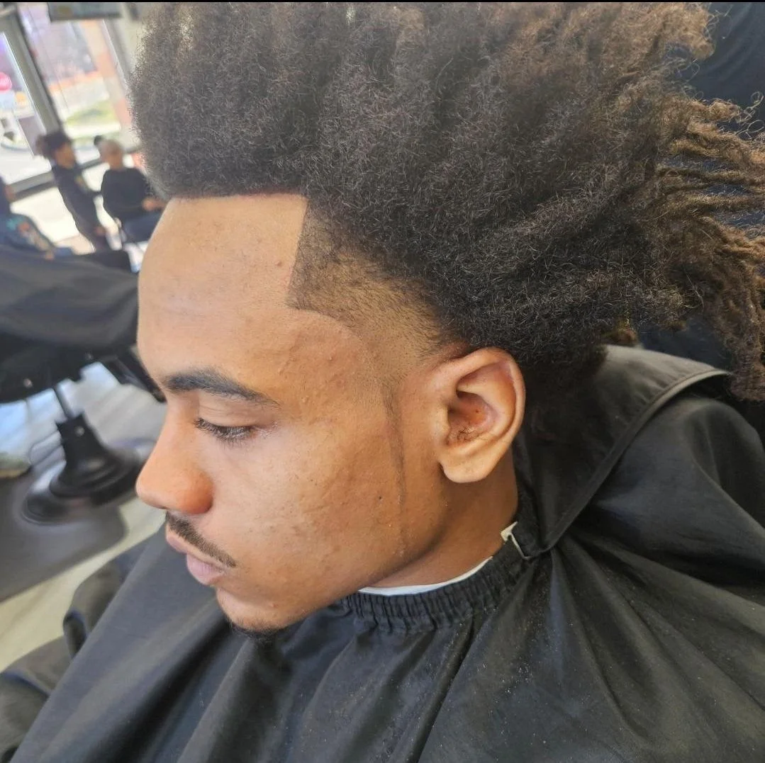 Side view of a men's freeform loc style with a sharp edge-up and tapered sides, done at Gem City Barbers in Erie, PA.