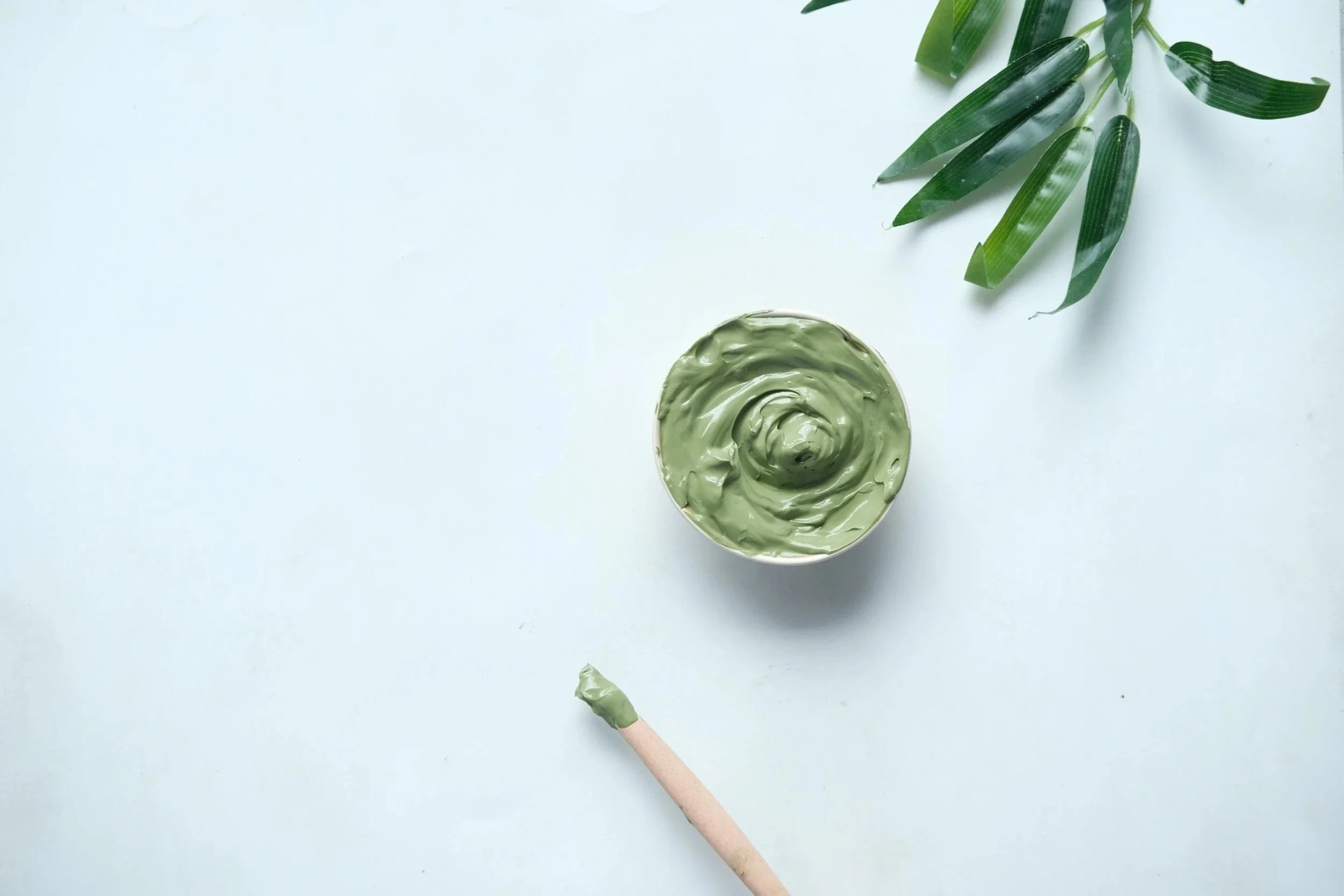 green creme facial mask on a blue background