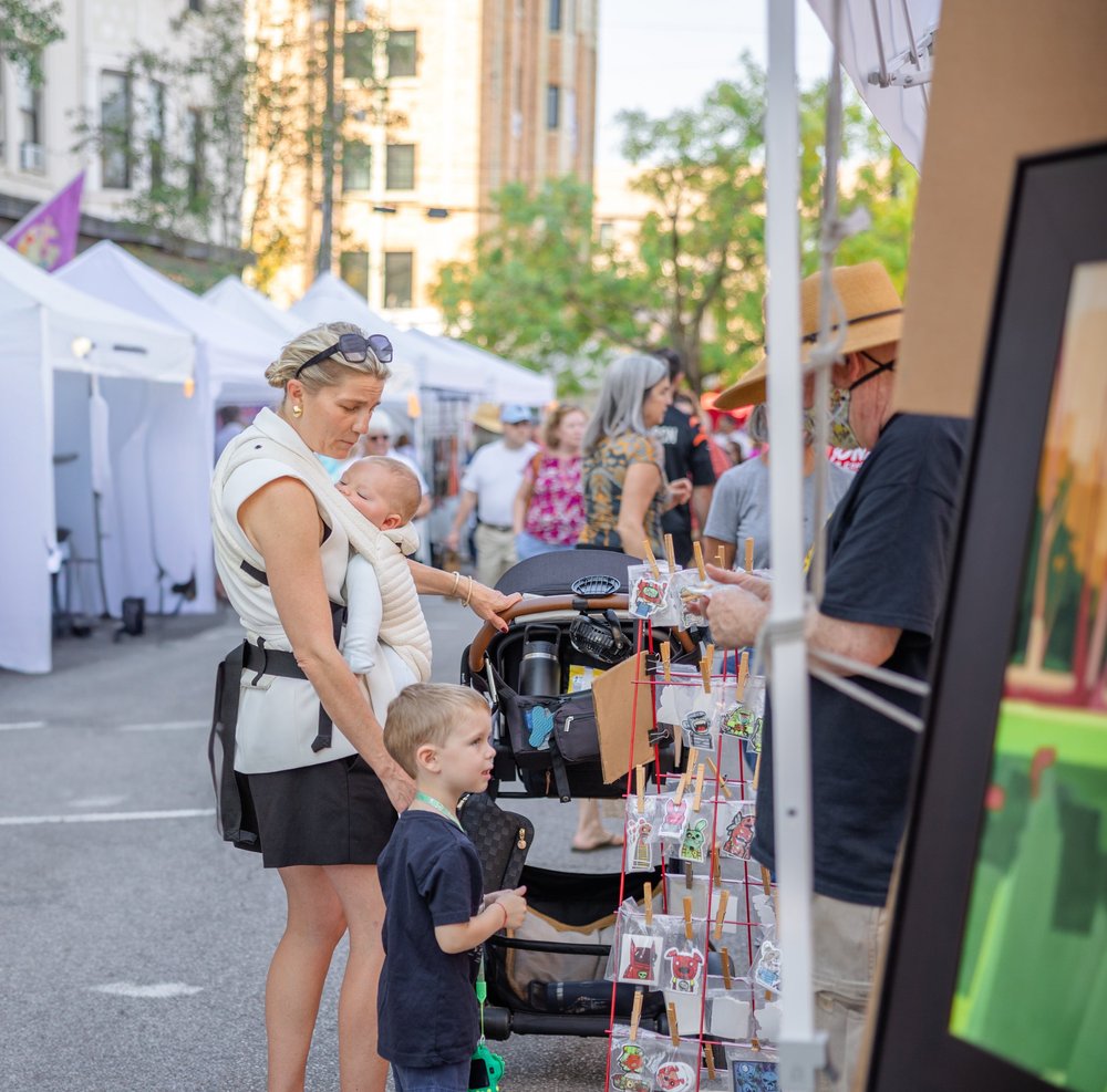Visitors browsing an outdoor art show