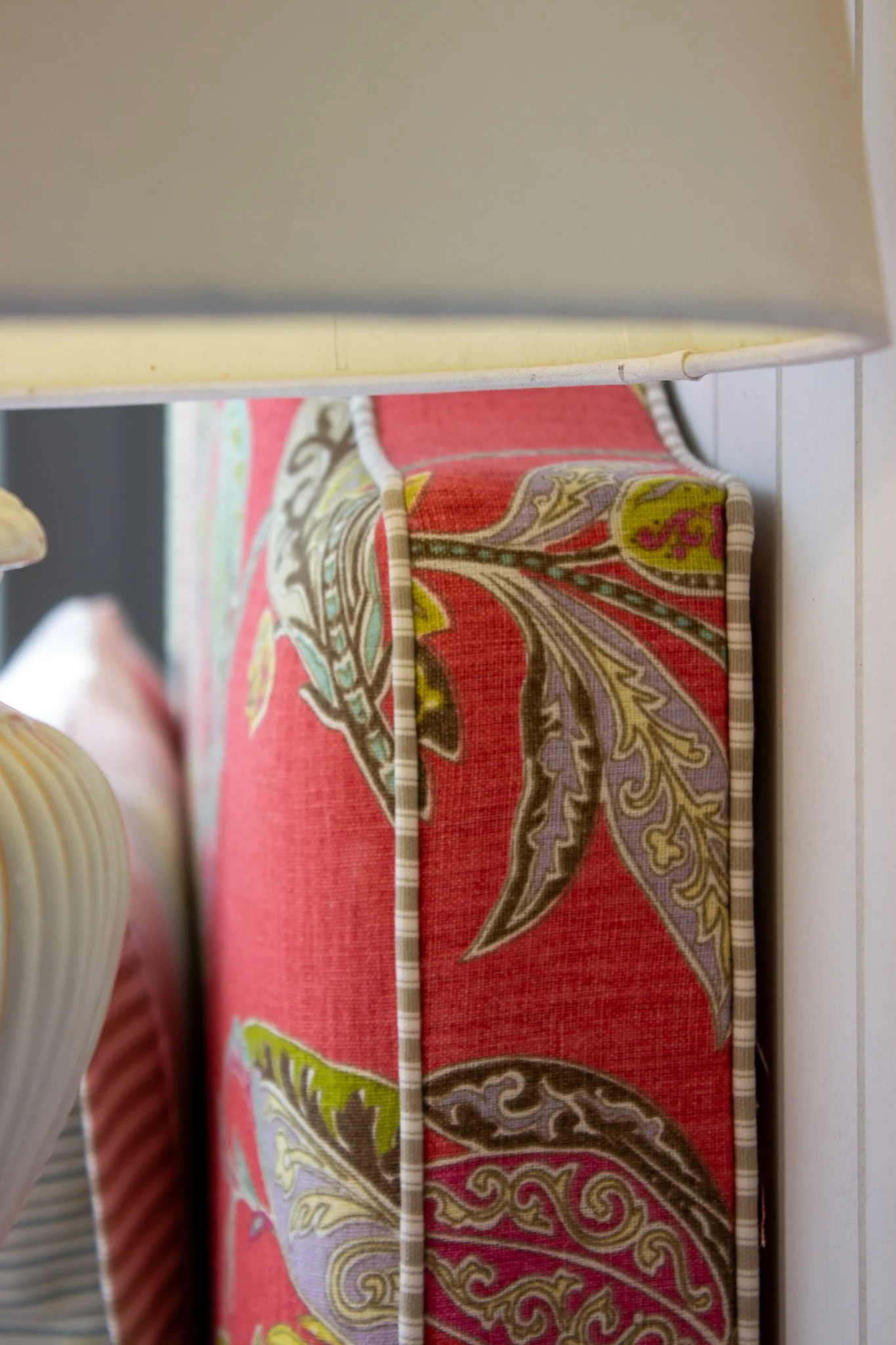 Close-up of a custom headboard with a floral pattern in shades of red, yellow, purple, and green.
