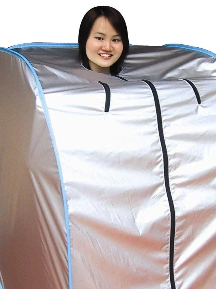 Pic of a woman inside a Relax brand Far Infrared Therapy tent with her head sticking out.