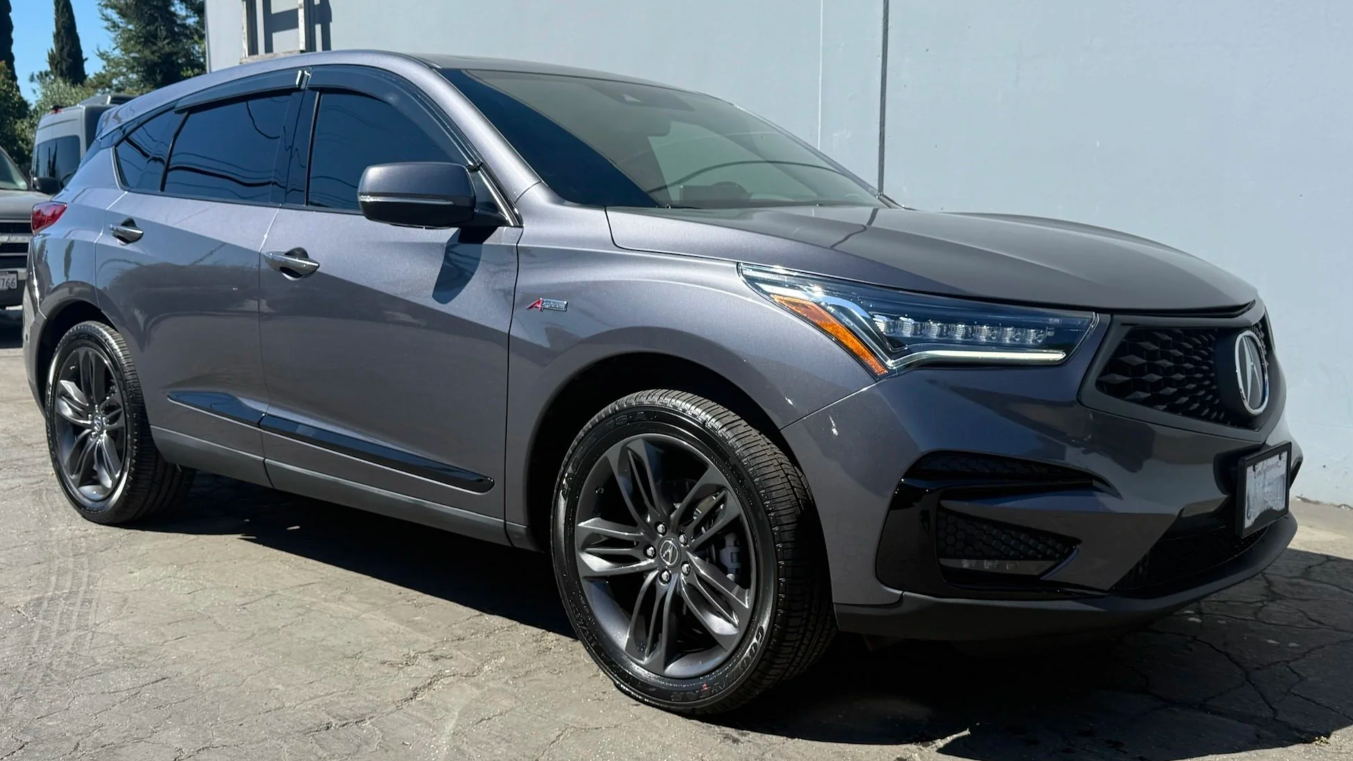 Gray Acura SUV parked on pavement.