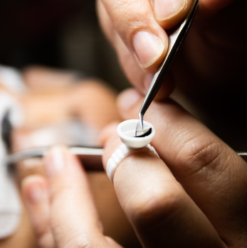 Close-up of a technician performing a detailed eyelash extension service