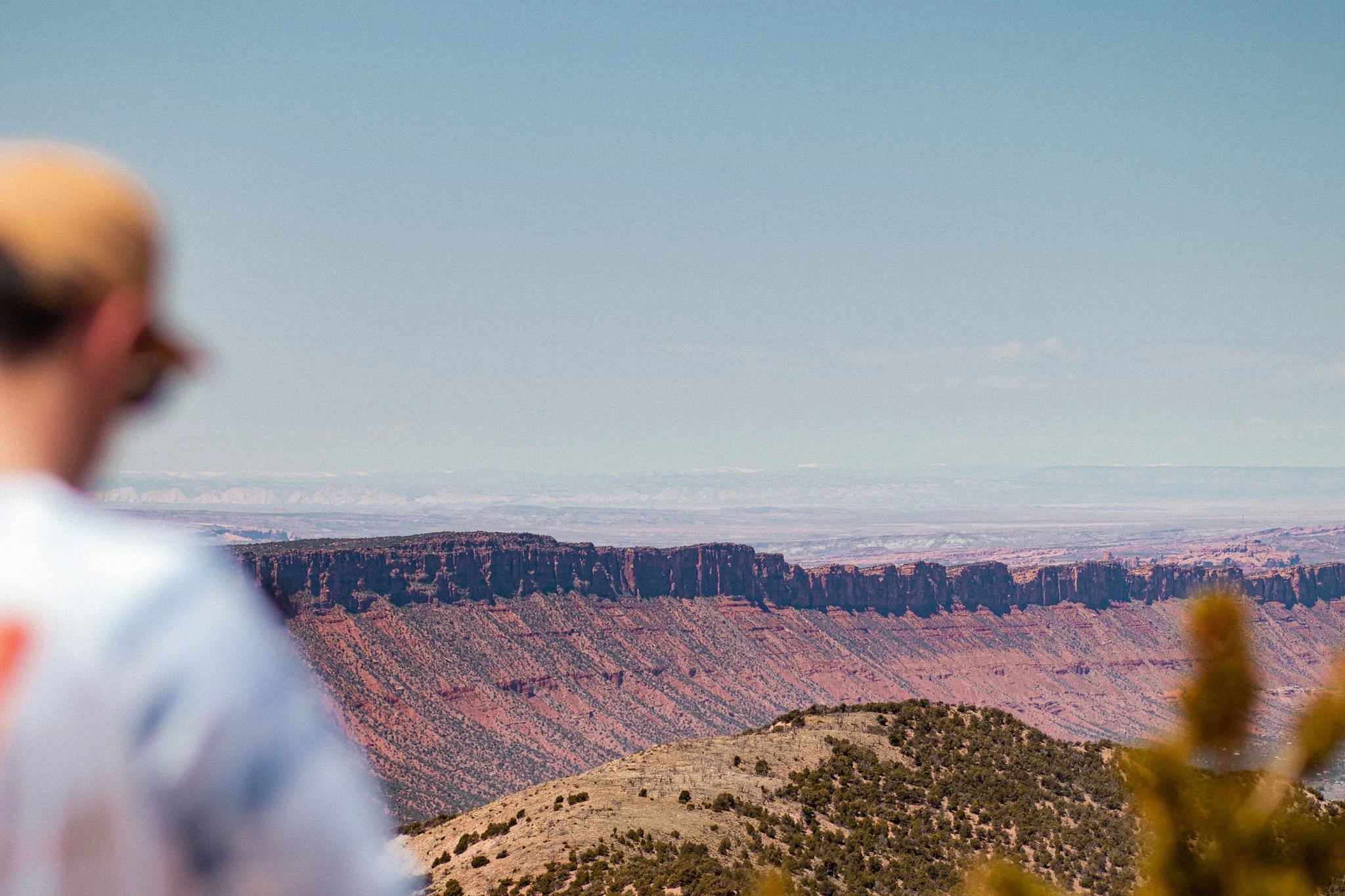 Person overlooking a desert canyon landscape from a mountain viewpoint in Utah.