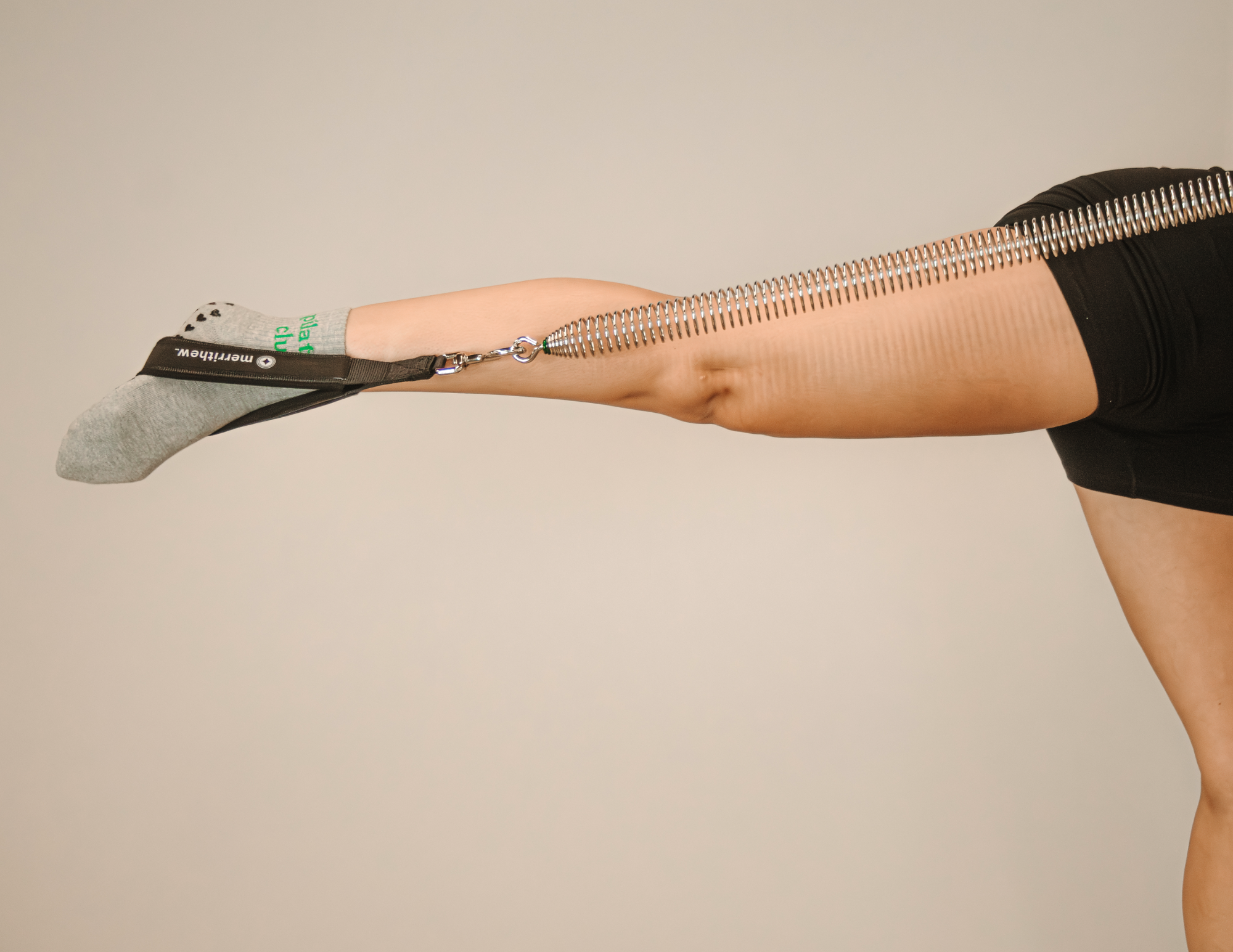 Close-up of a leg using a Pilates reformer with spring resistance