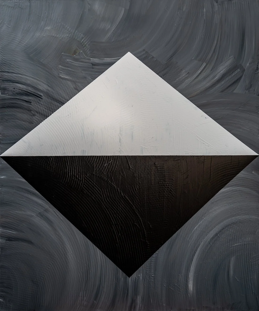 A still white and black diamond alone in a swept grey field