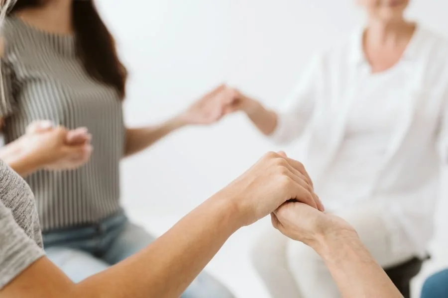 Group of people holding hands. Join Sarah for an interactive energy medicine workshop in Bozeman MT. This aura and chakra healing class near me will teach you the foundation of energy work. Gain access to the healer within.