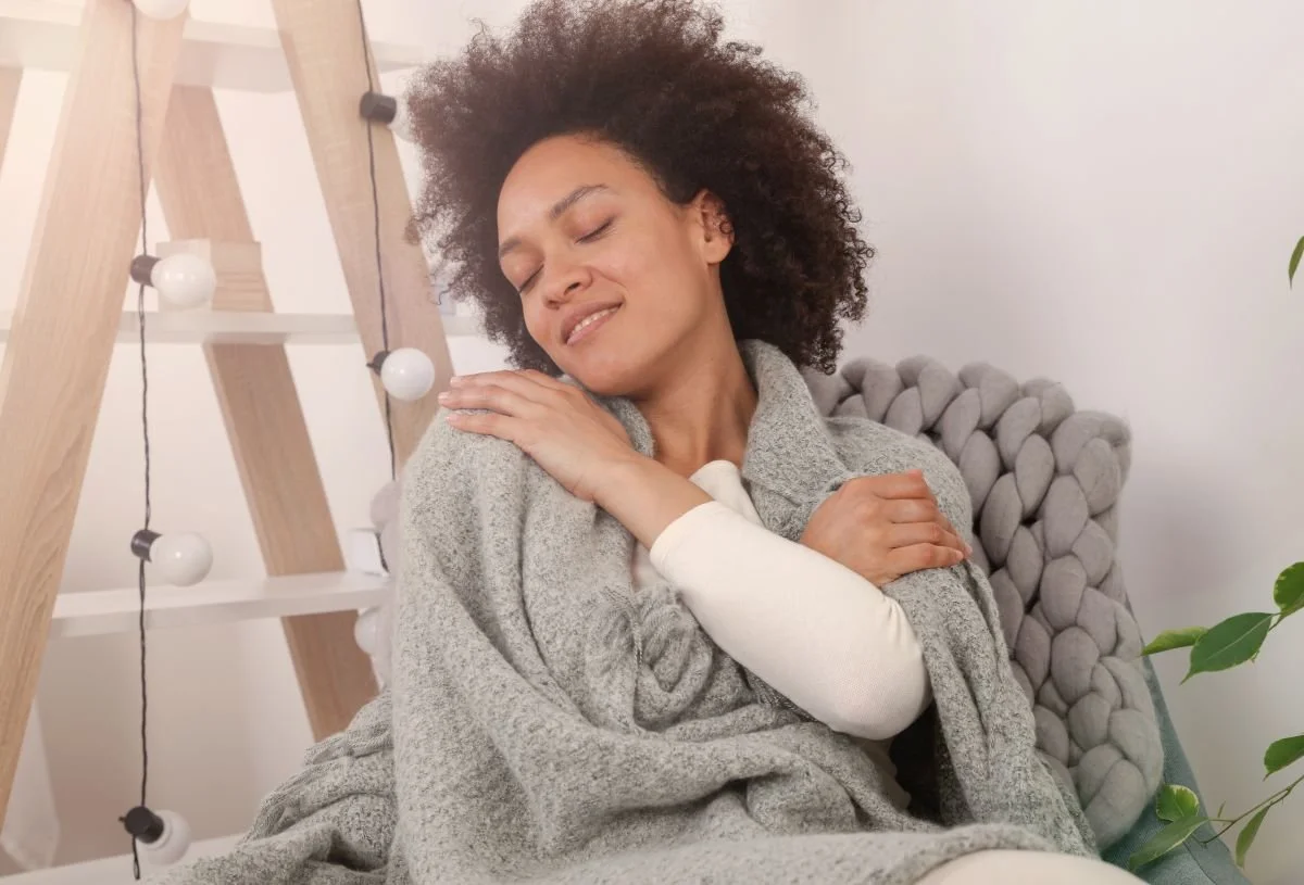 Women in a chair giving herself a hug. A core essence infusion helps you embrace and love yourself completely. You'll begin to see the perfection in your imperfection.