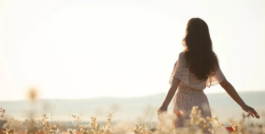 Woman in a field with her arms open looking toward the sun. Join Certified Master Healer, Sarah for a healing journey within. This work isn't about fixing it's about returning to who you have always been.