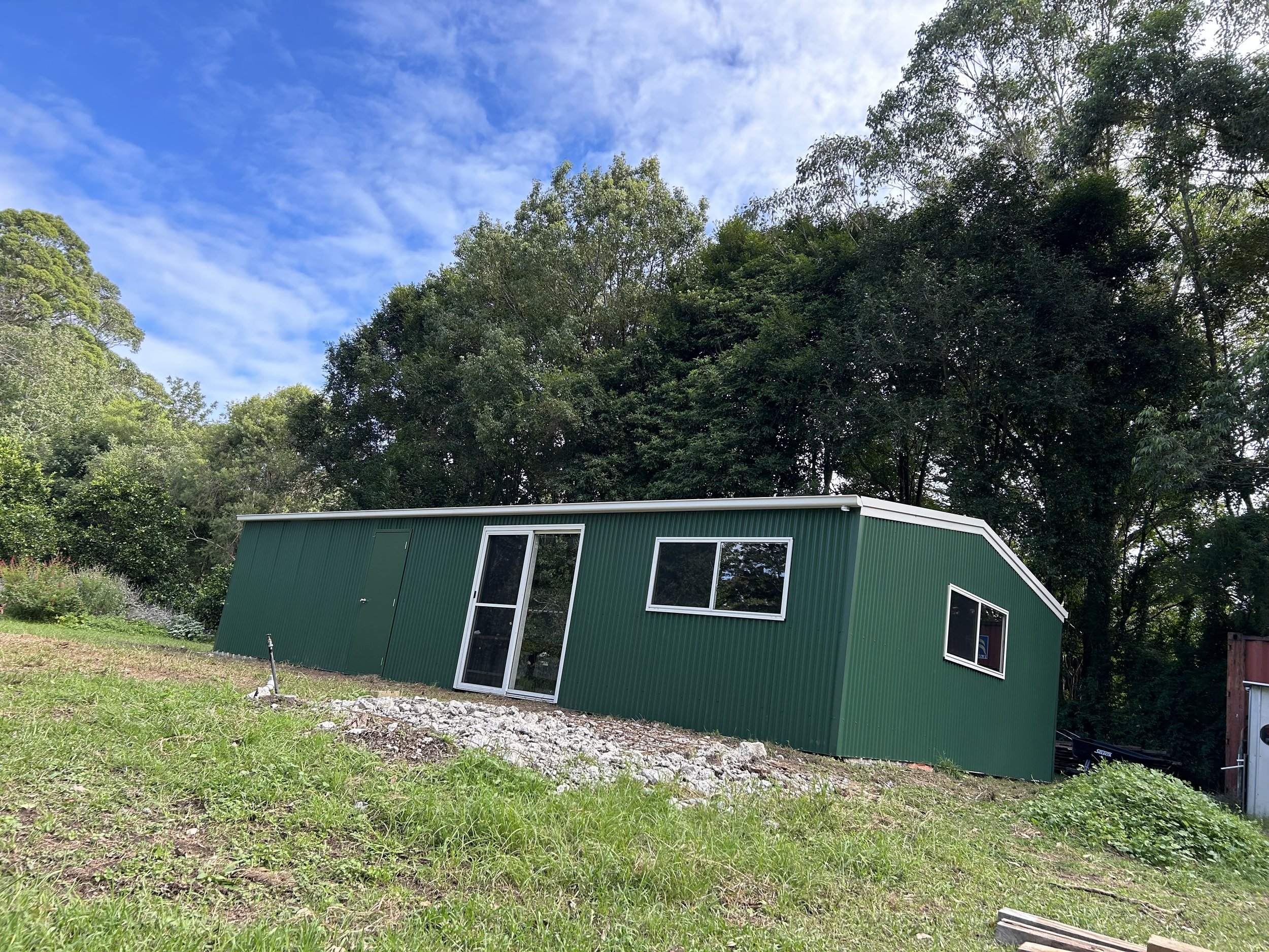 Green and white shed wih sliding door
