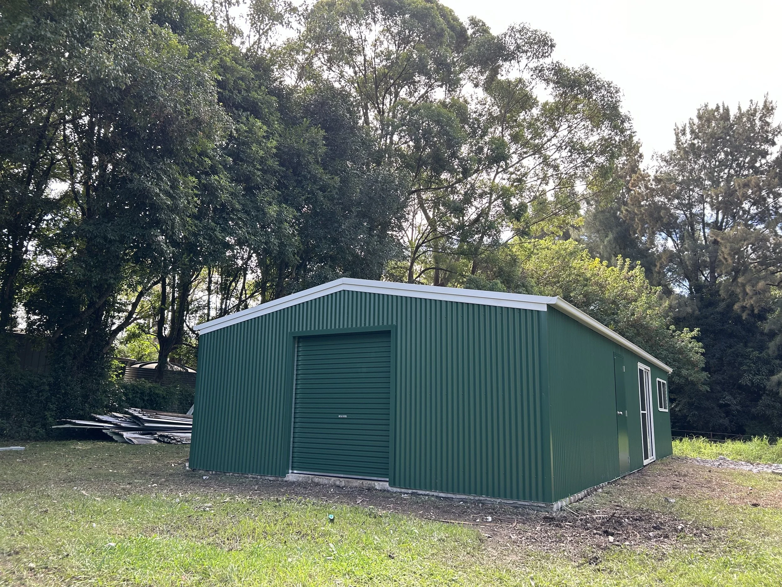 Green shed with roller door