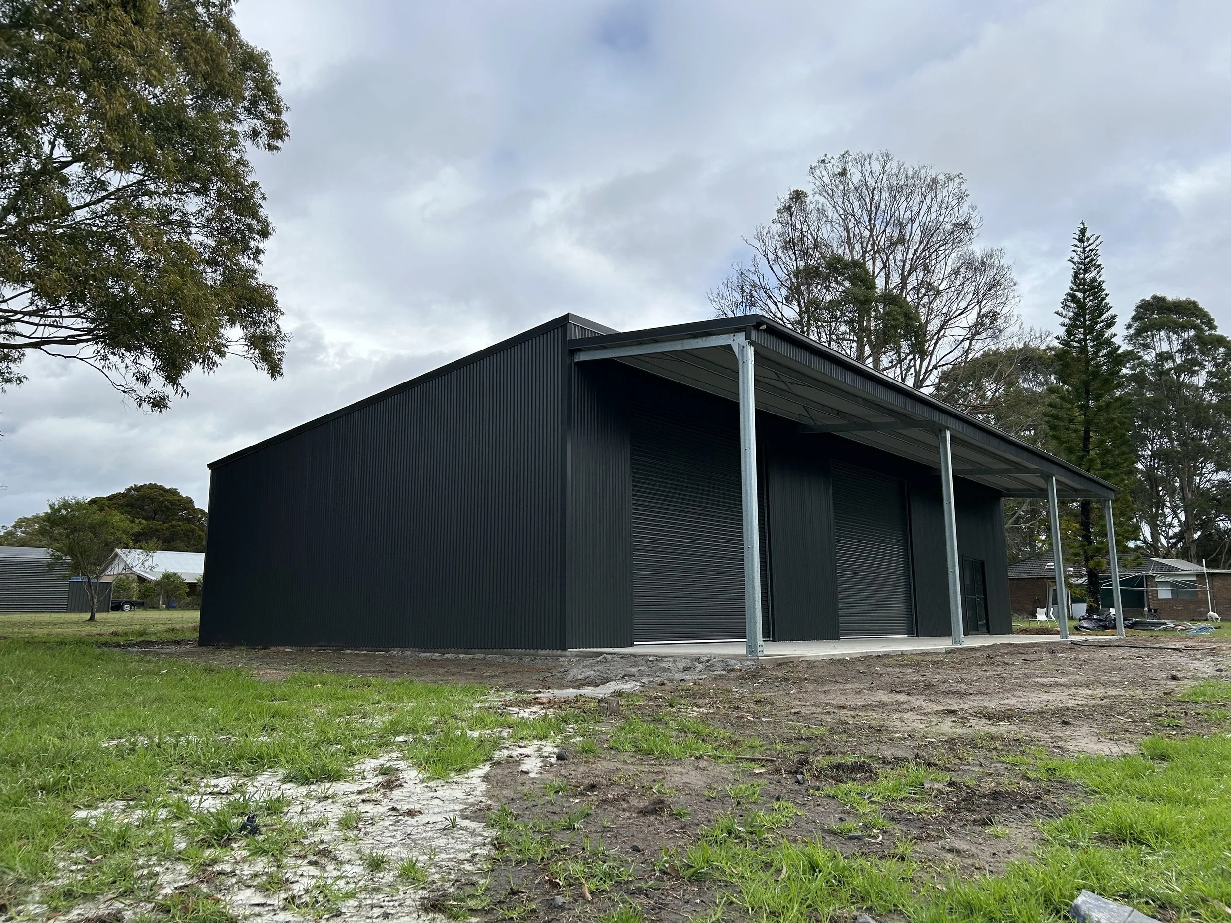 Black double roller door shed with verandah