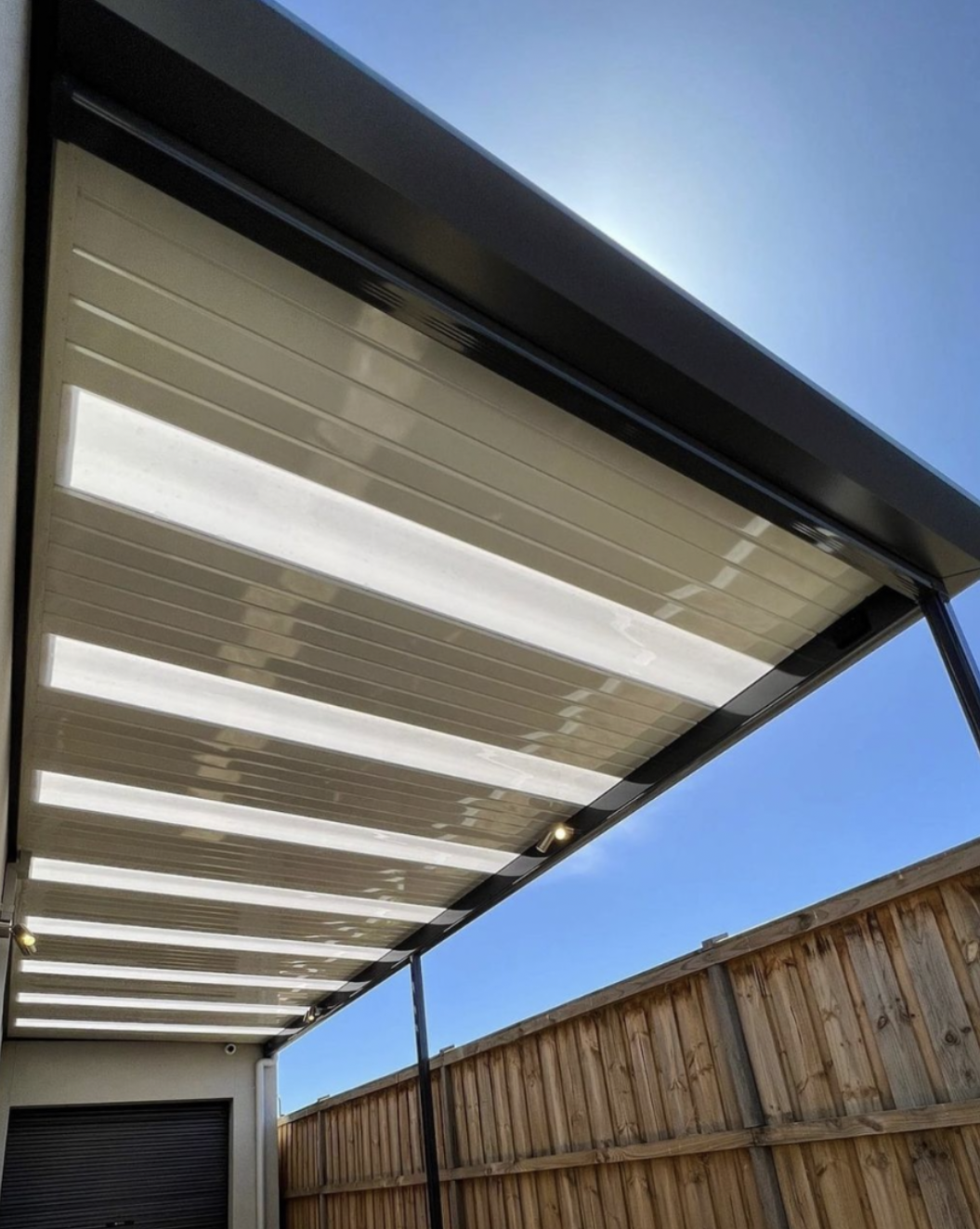 Black pergola with white roofing and sky lights