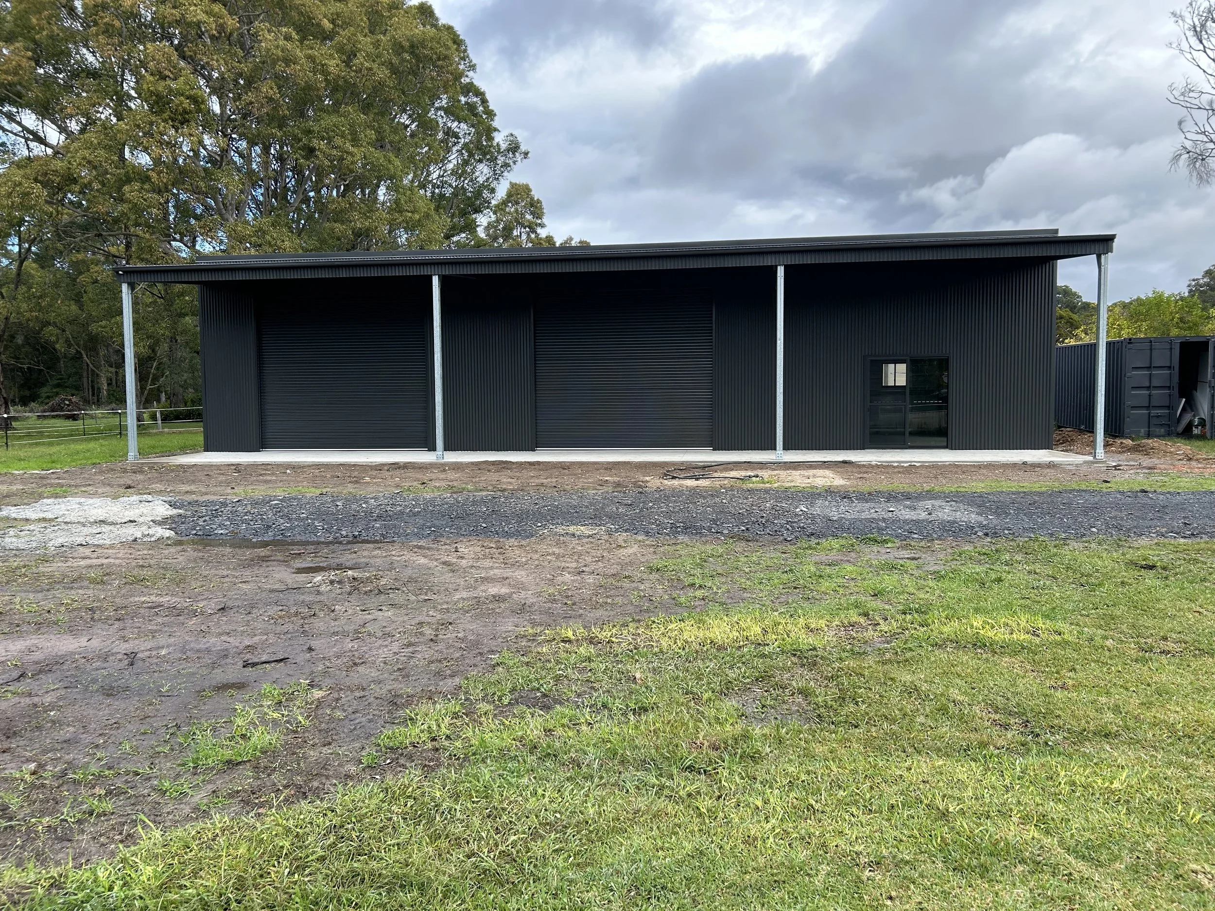 Black double roller door shed with verandah