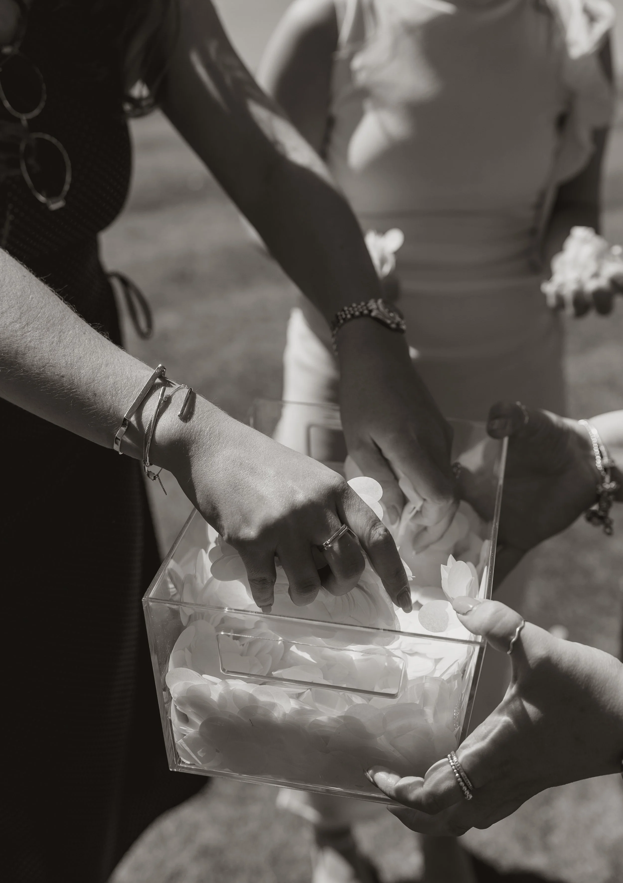 People passing a box filled with tissue paper at an outdoor event.