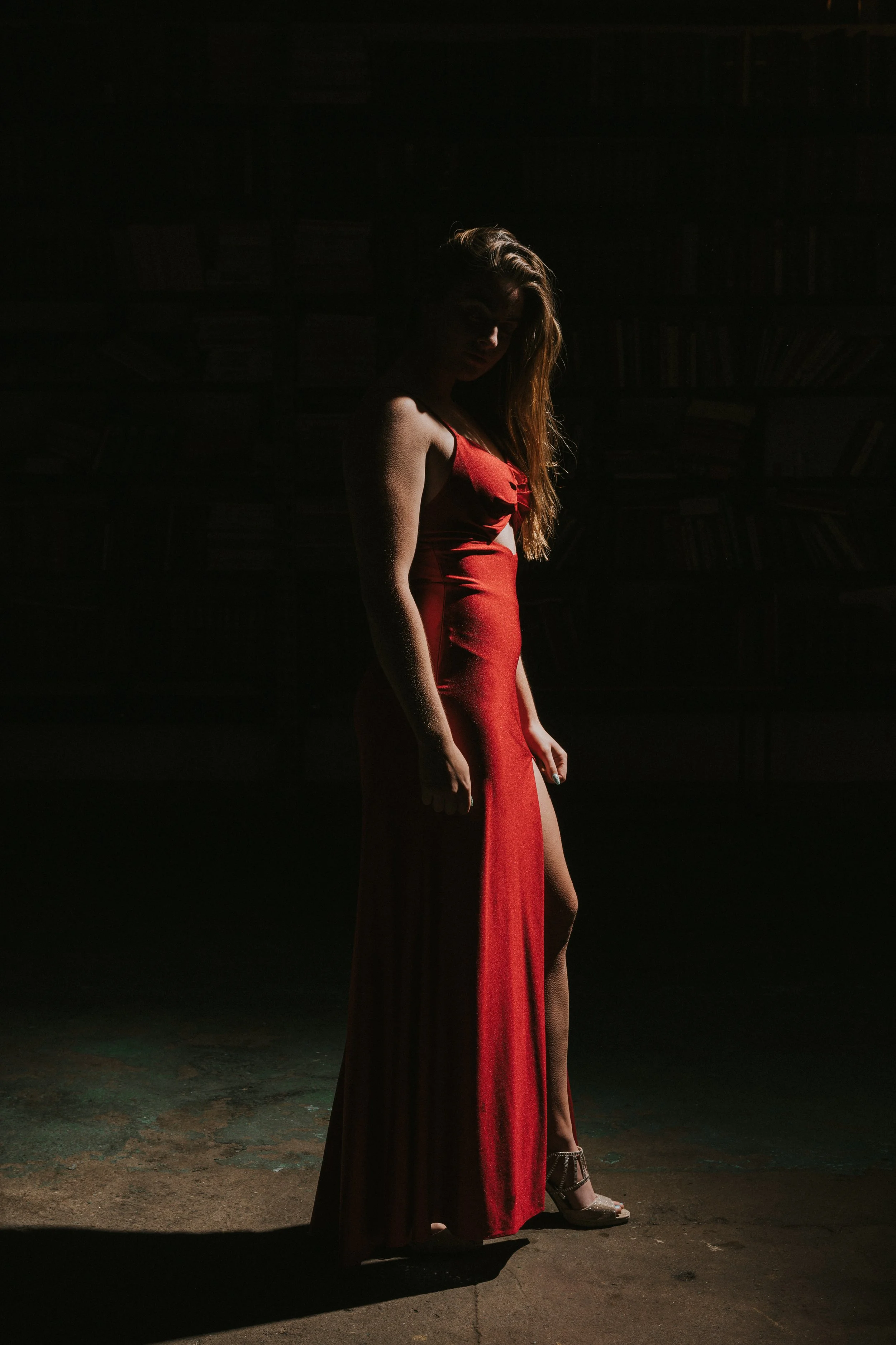 Moody full-body portrait in red dress with dramatic shadow lighting, cinematic portrait photography