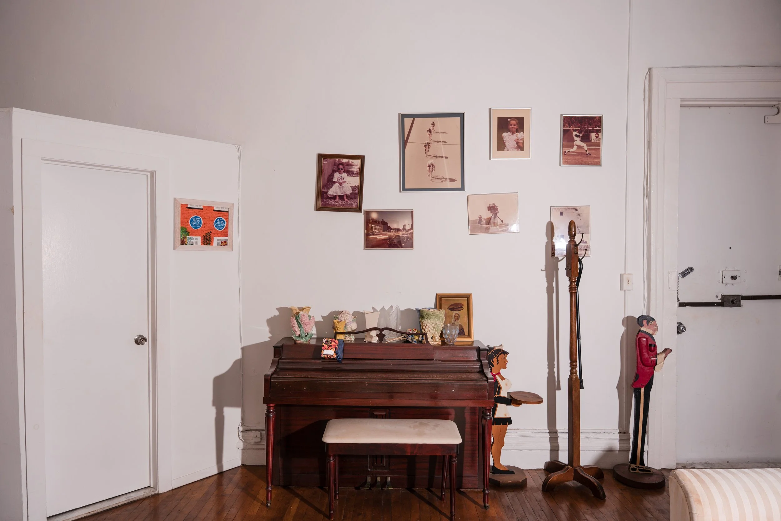 Vintage upright piano with personal photographs and decorative objects displayed above.