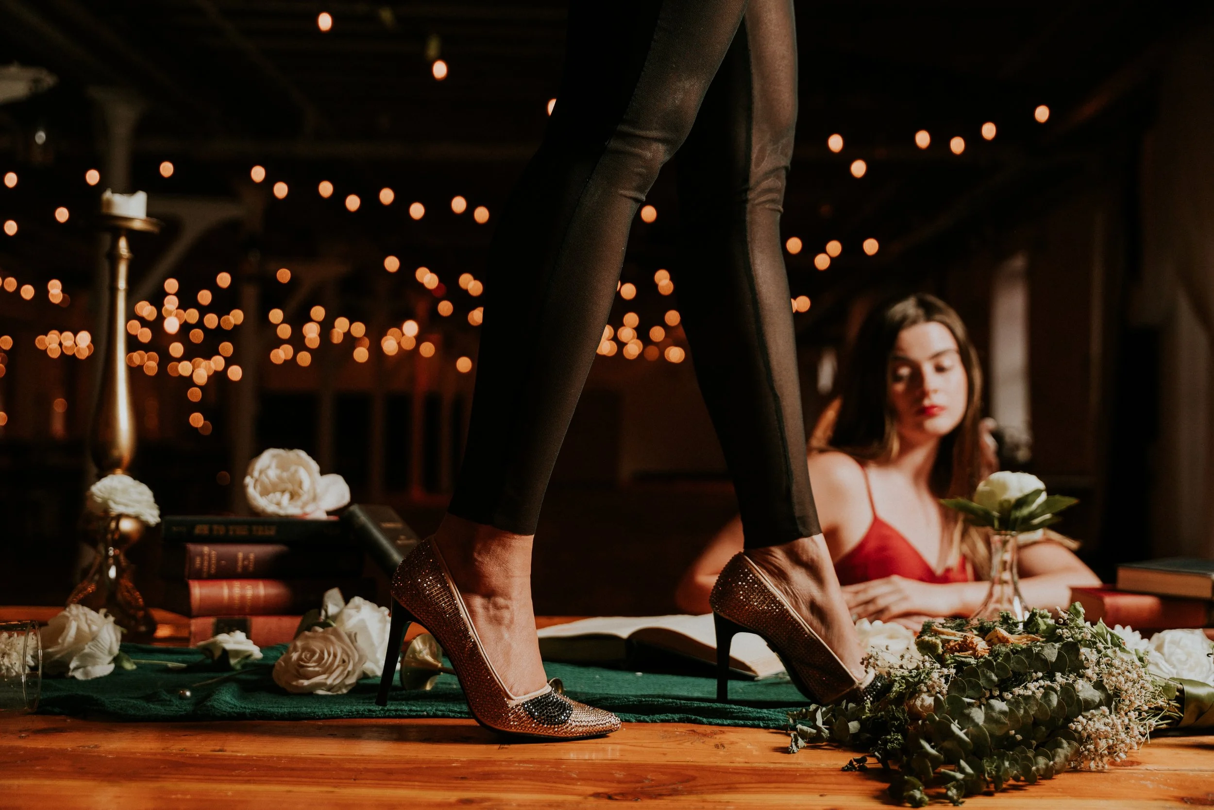 Fashion detail shot of gold heels and flowers on table, editorial photography New Jersey
