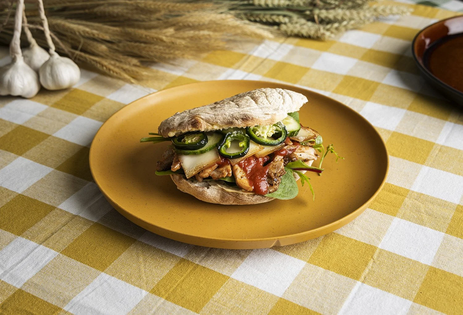 Bilde av kylling, jalapenos, røkt ost og salat servert i pita - sadwich - matfoto
