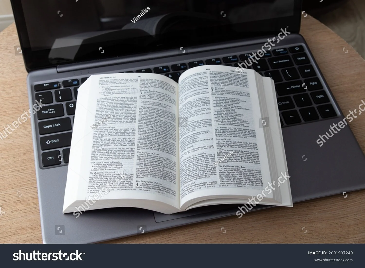 stock-photo-open-bible-and-laptop-on-the-work-table-bible-study-online-concept-2091997249.jpg