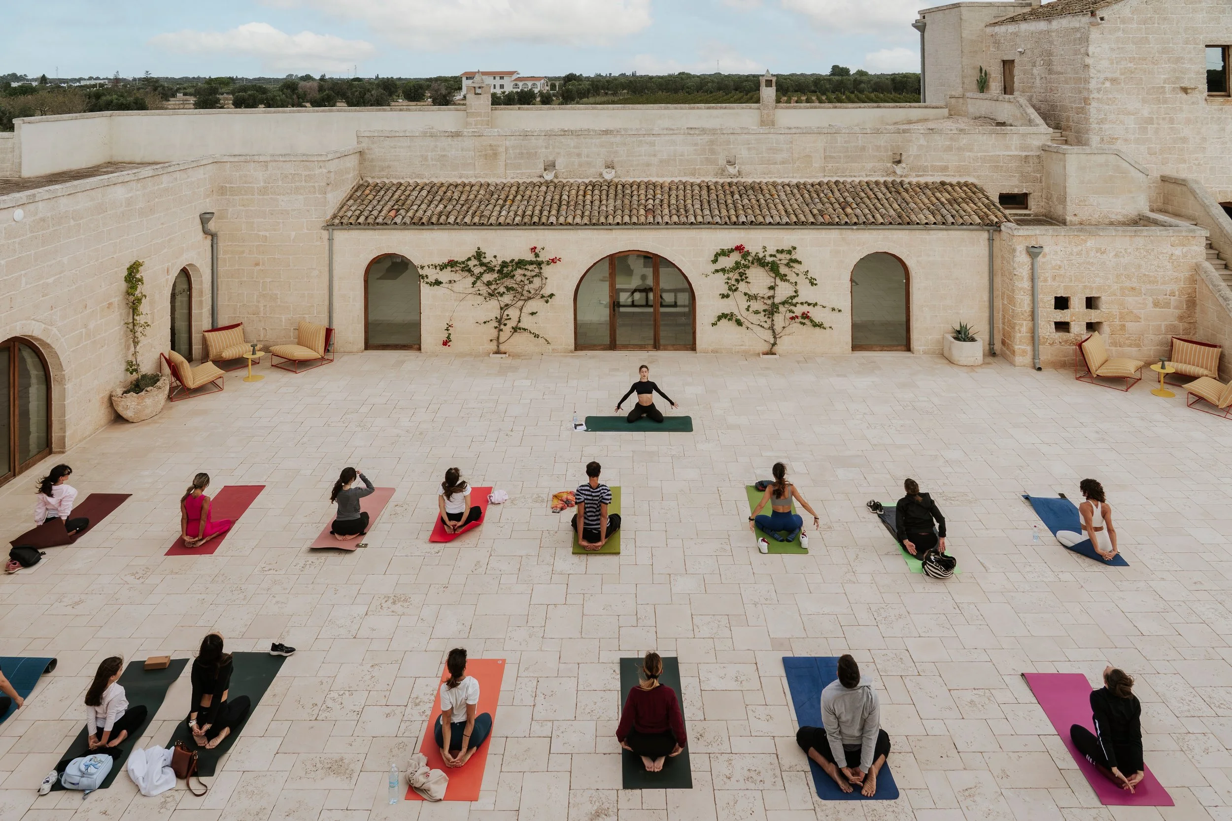 Interior of a rustic dining room featuring stone arches, a round wooden table with chairs, and a mix of contemporary and traditional furniture.