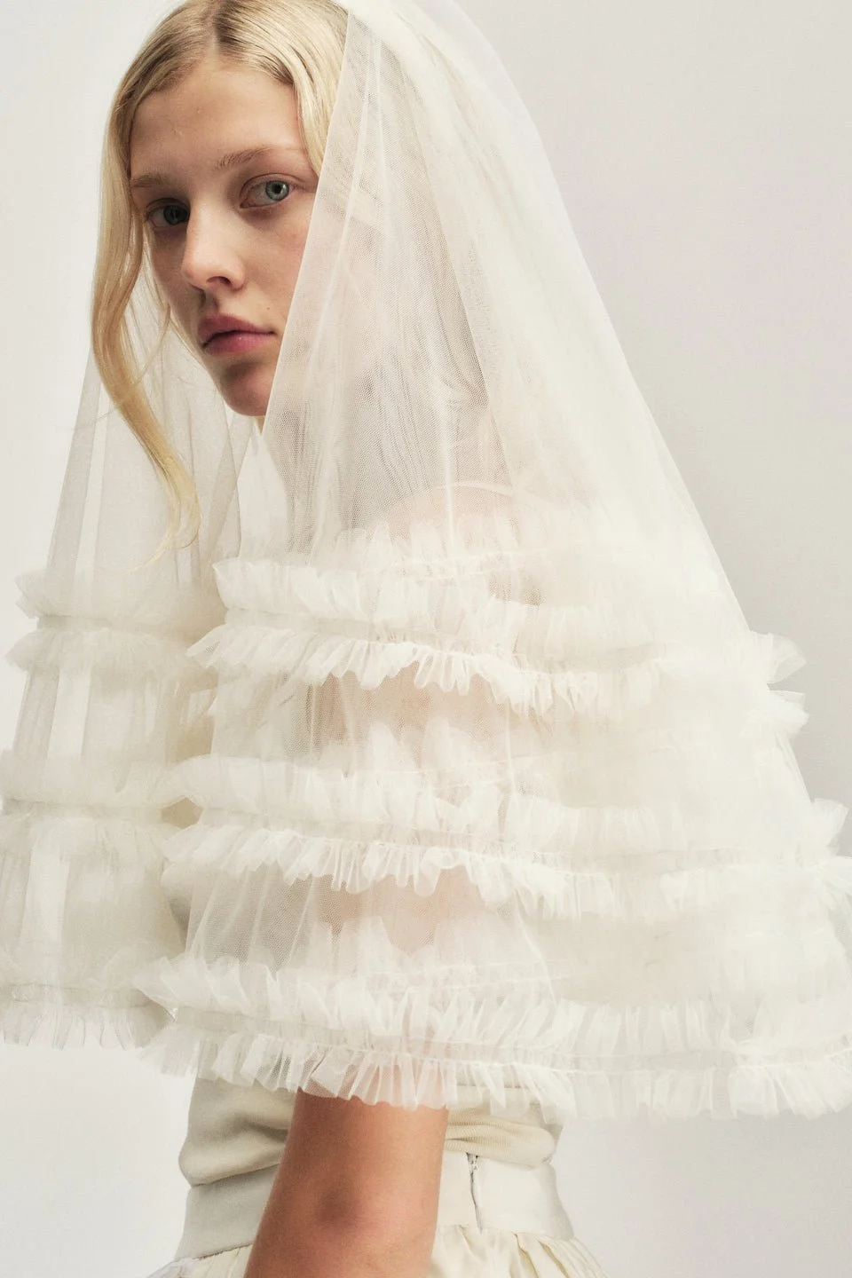 Young woman in sheer veil and white dress