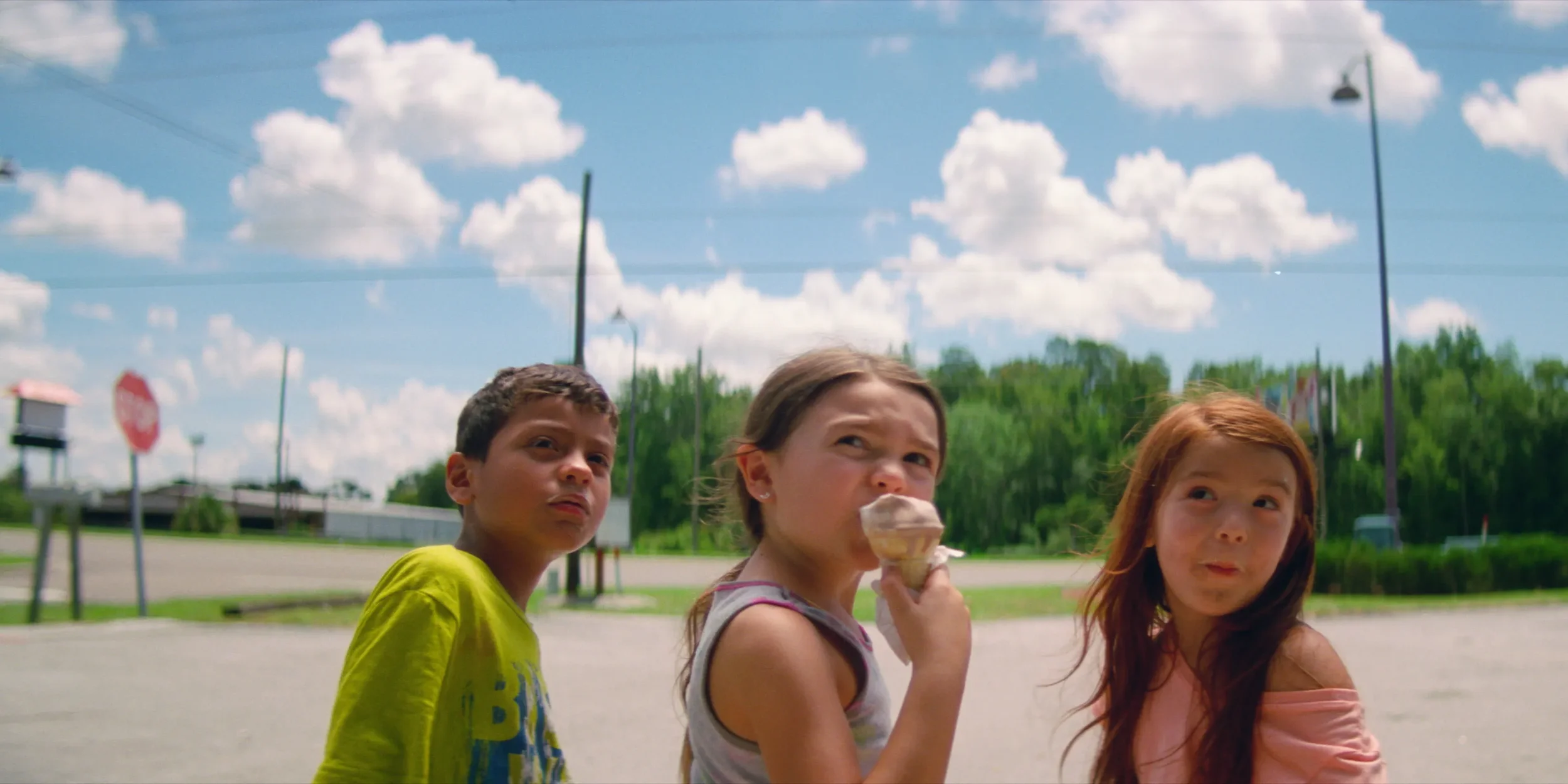 Three children outdoors on a sunny day