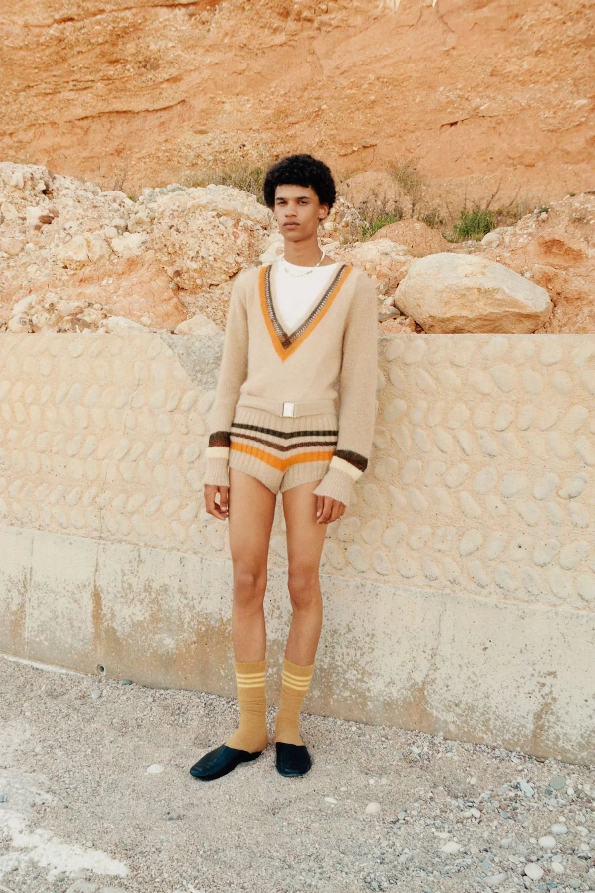 Person in beige striped sweater vest outdoors
