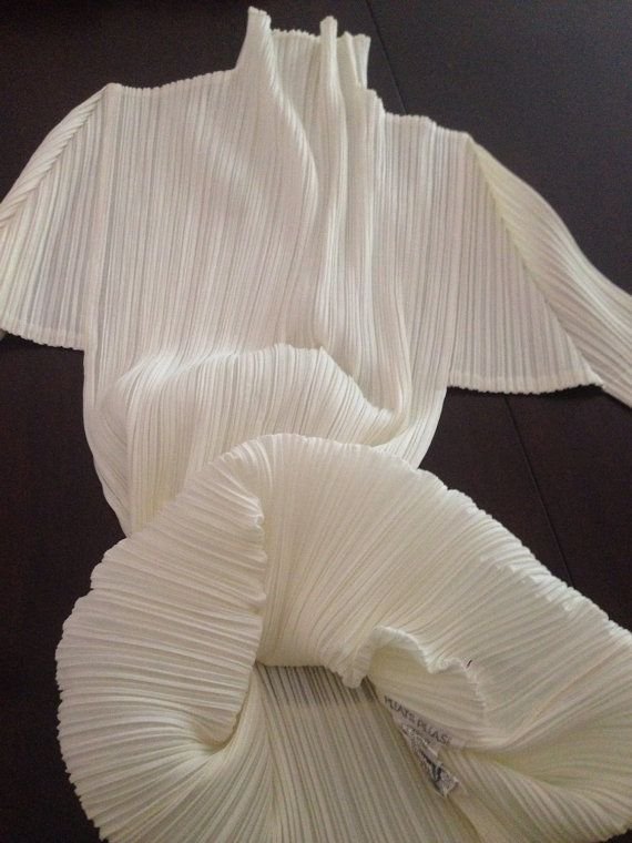 White pleated fabric on dark surface - pleats please Issey Miyake