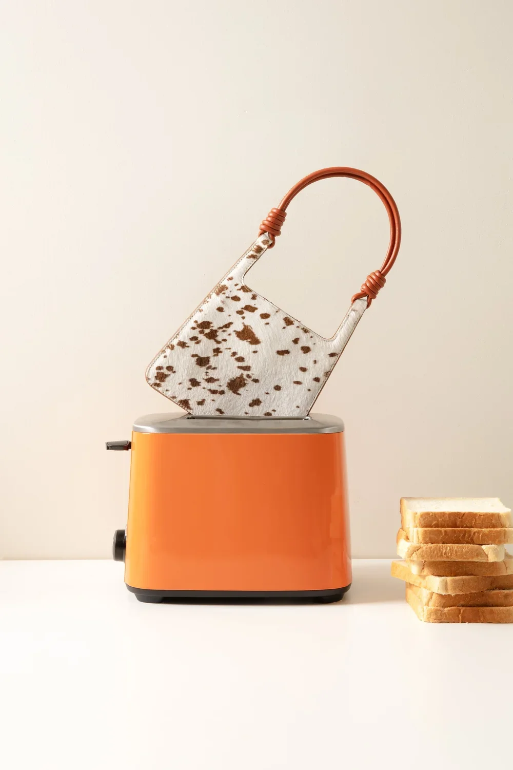 Still life: SIEDRES handbag in toaster, bread stacked beside