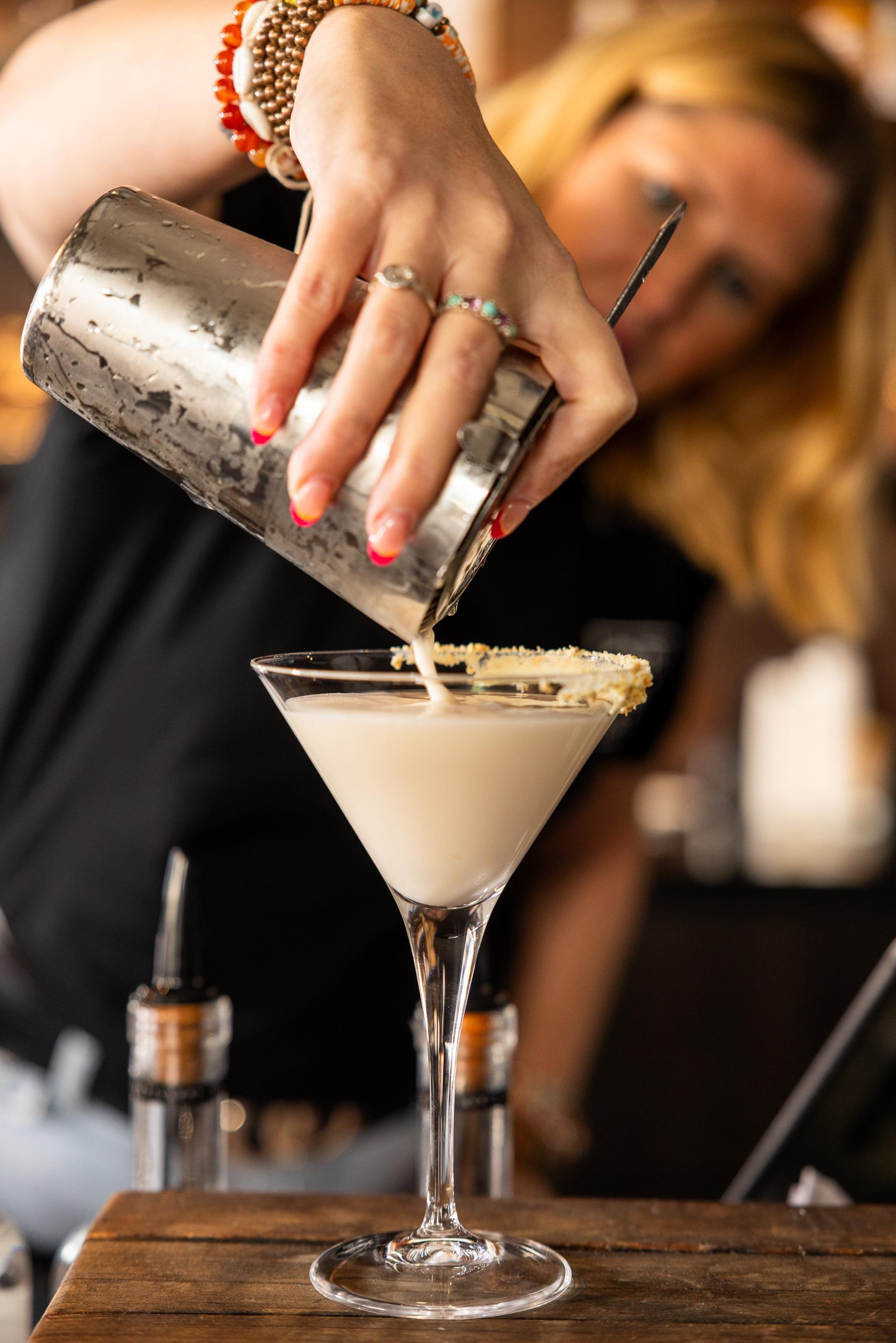 Laurie’s customers, Mariana and Carmen holding hands on a green lawn on their wedding day.
