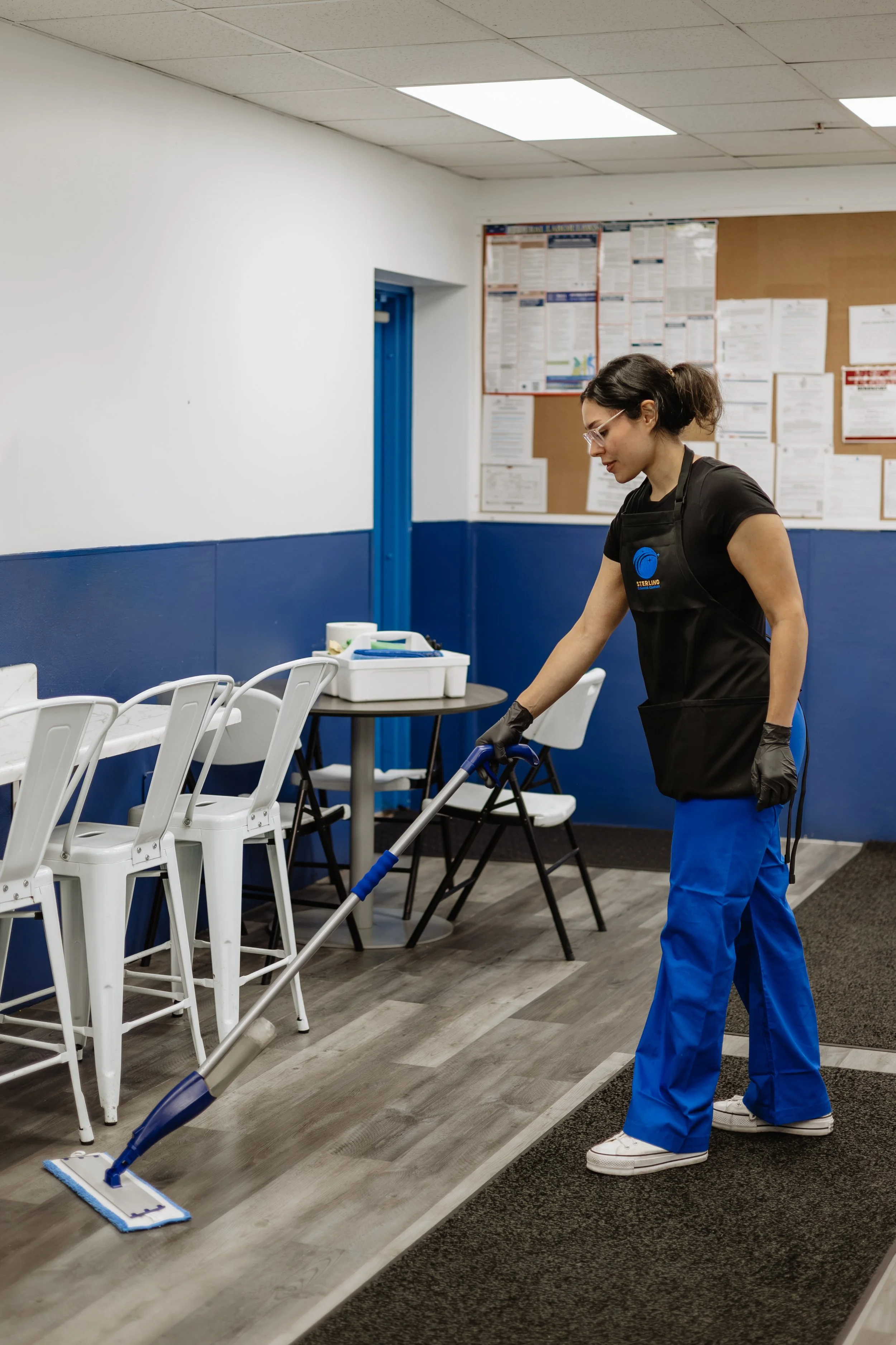 Marla Rios mopping an office breakroom floor.
