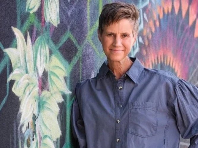 woman standing in front of mural of yucca plant