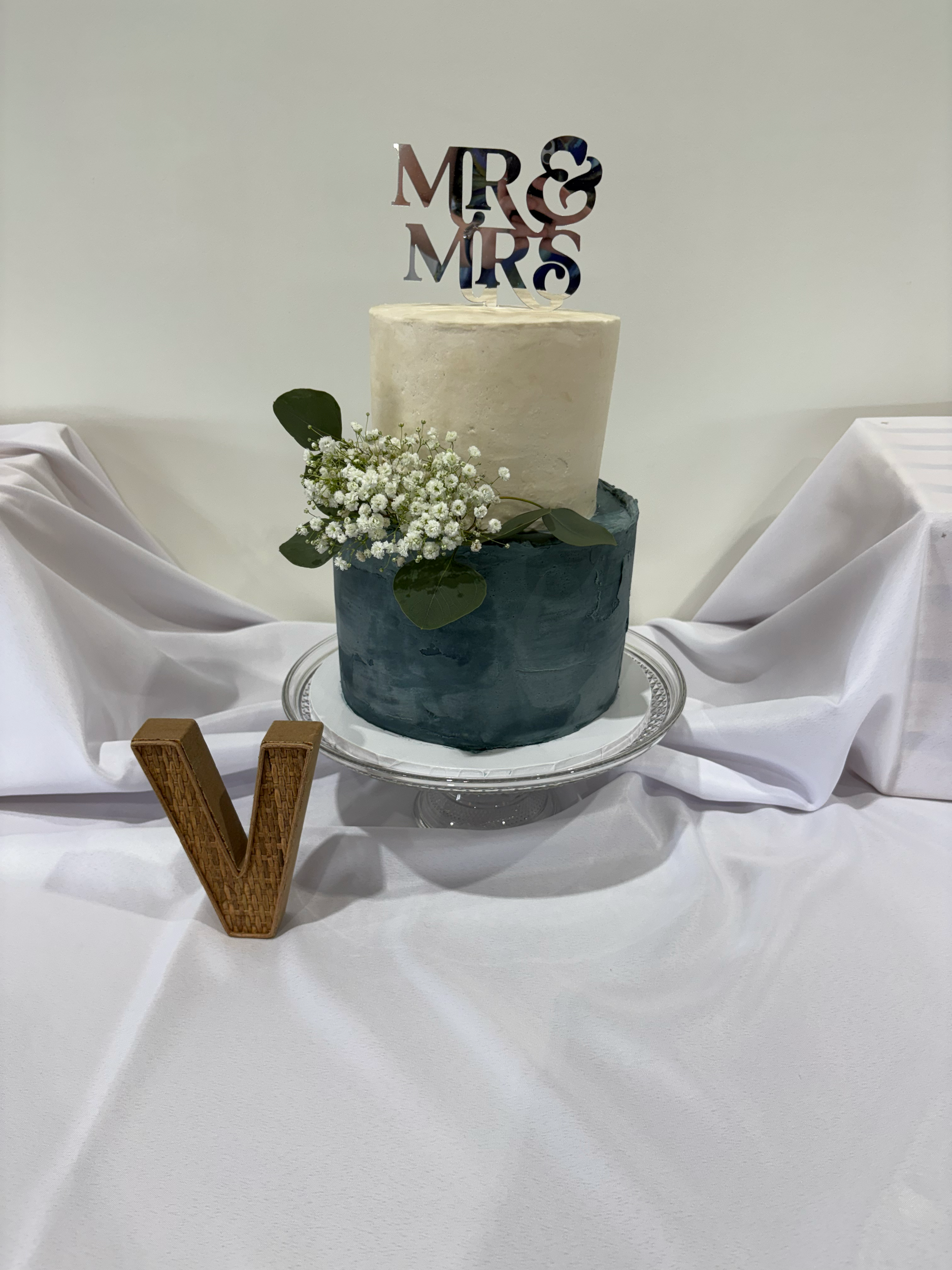 Dusty blue bottom tier with texture, simple white top tier and wedding flowers to tie it all together