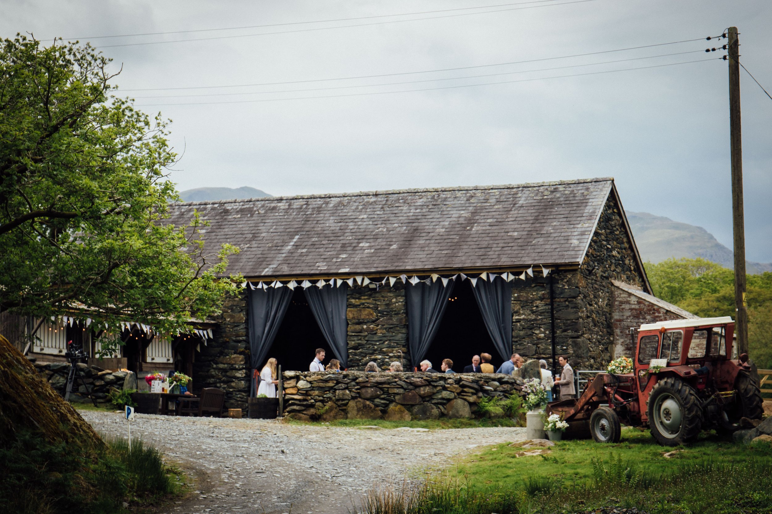 rustic barn with event guests outside with bunting lining the outside
