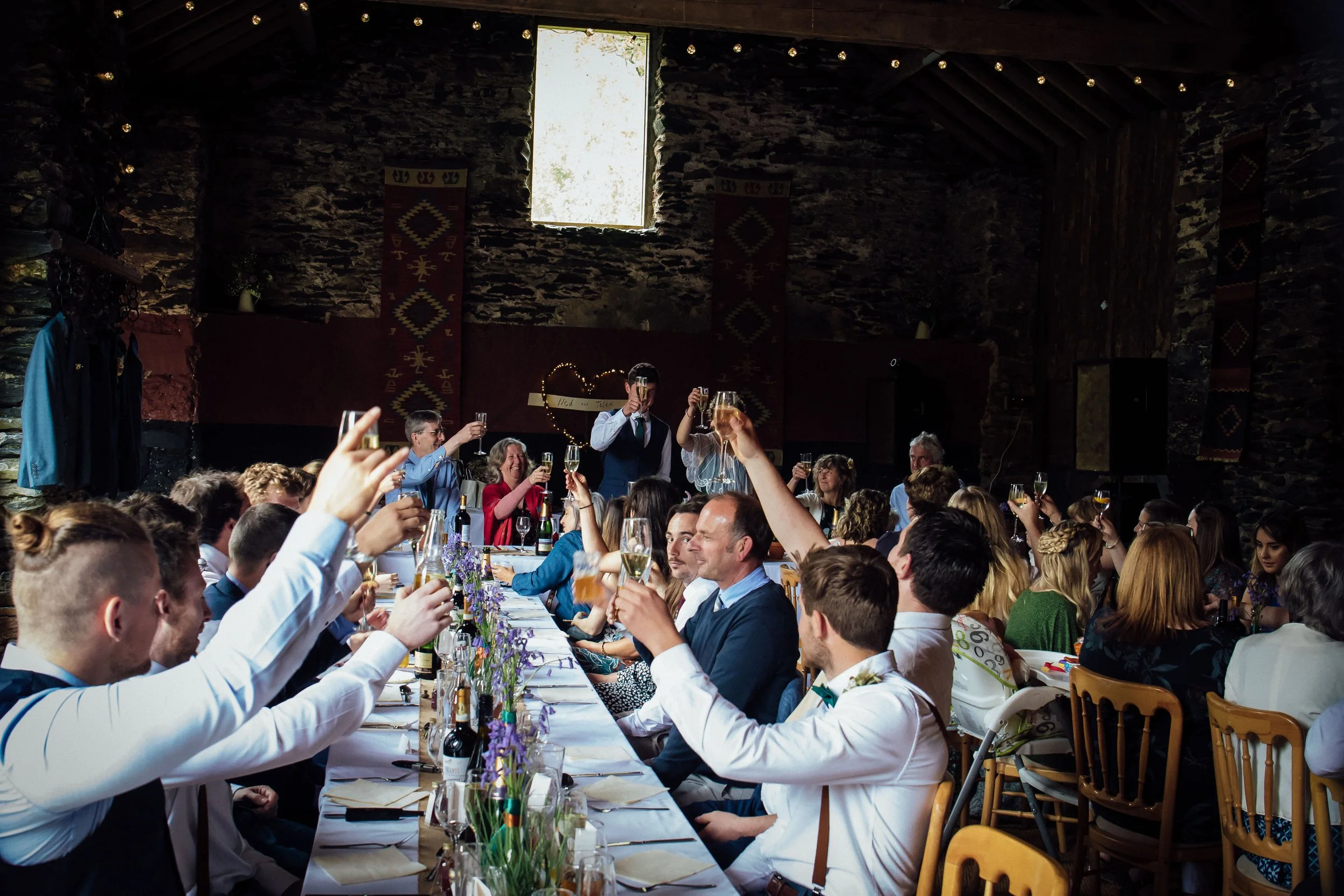 wedding guests toasting at wedding in small barn available to hire in north wales