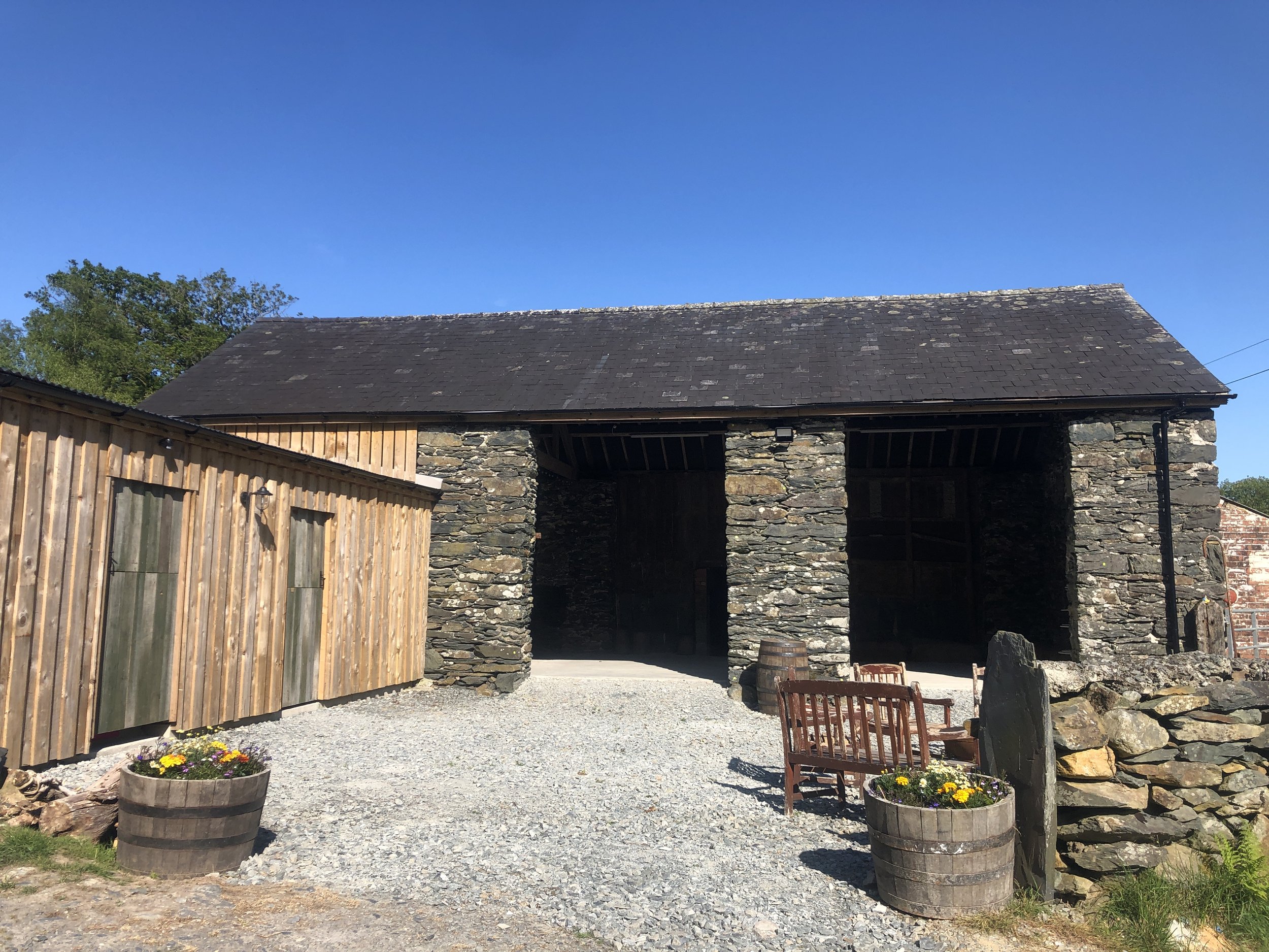 large slate barn with wooden extension and gravel driveway, available to hire for events in snowdonia