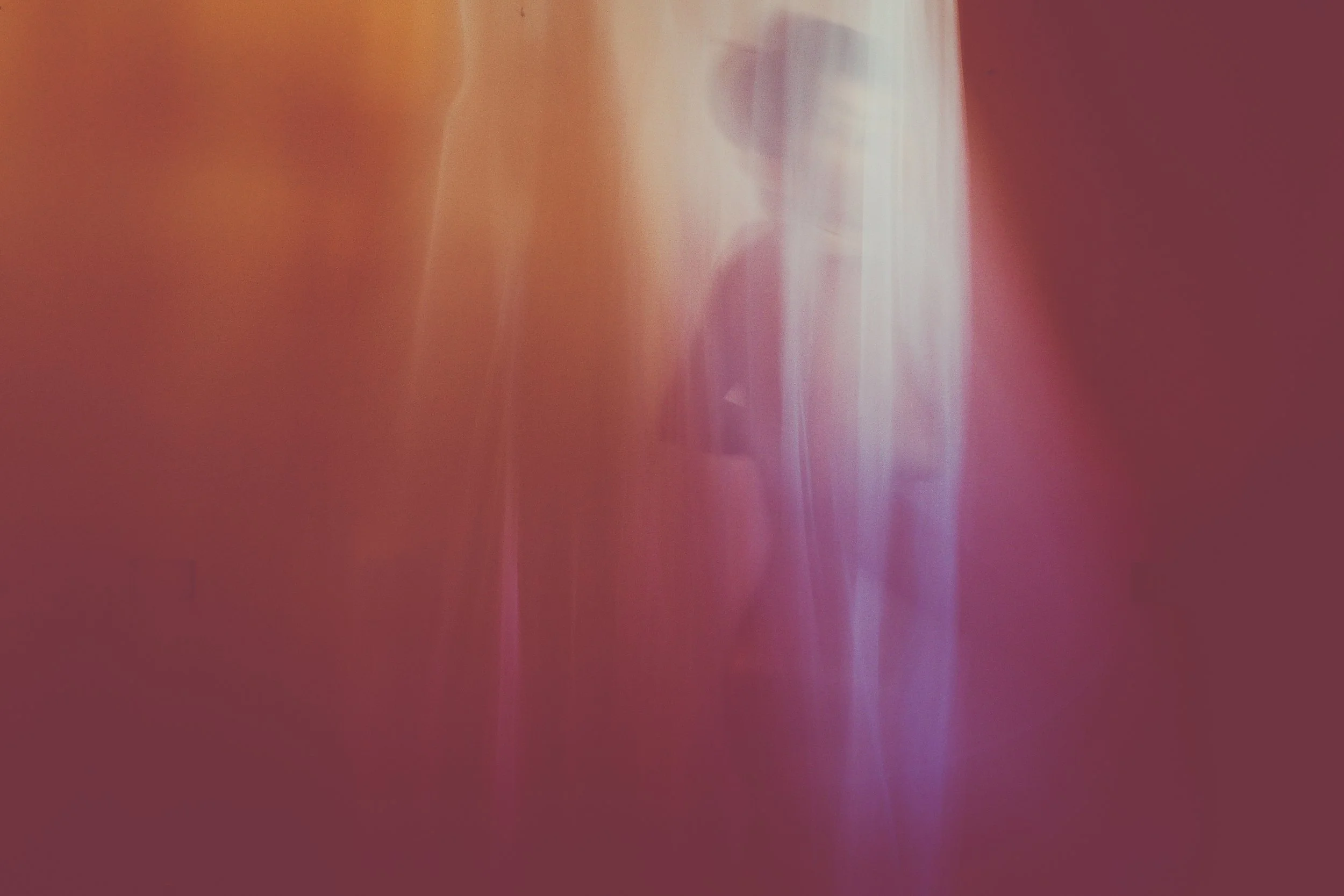 Immagine astratta con colori caldi come rosso, arancione e viola, con linee sfocate e irregolari