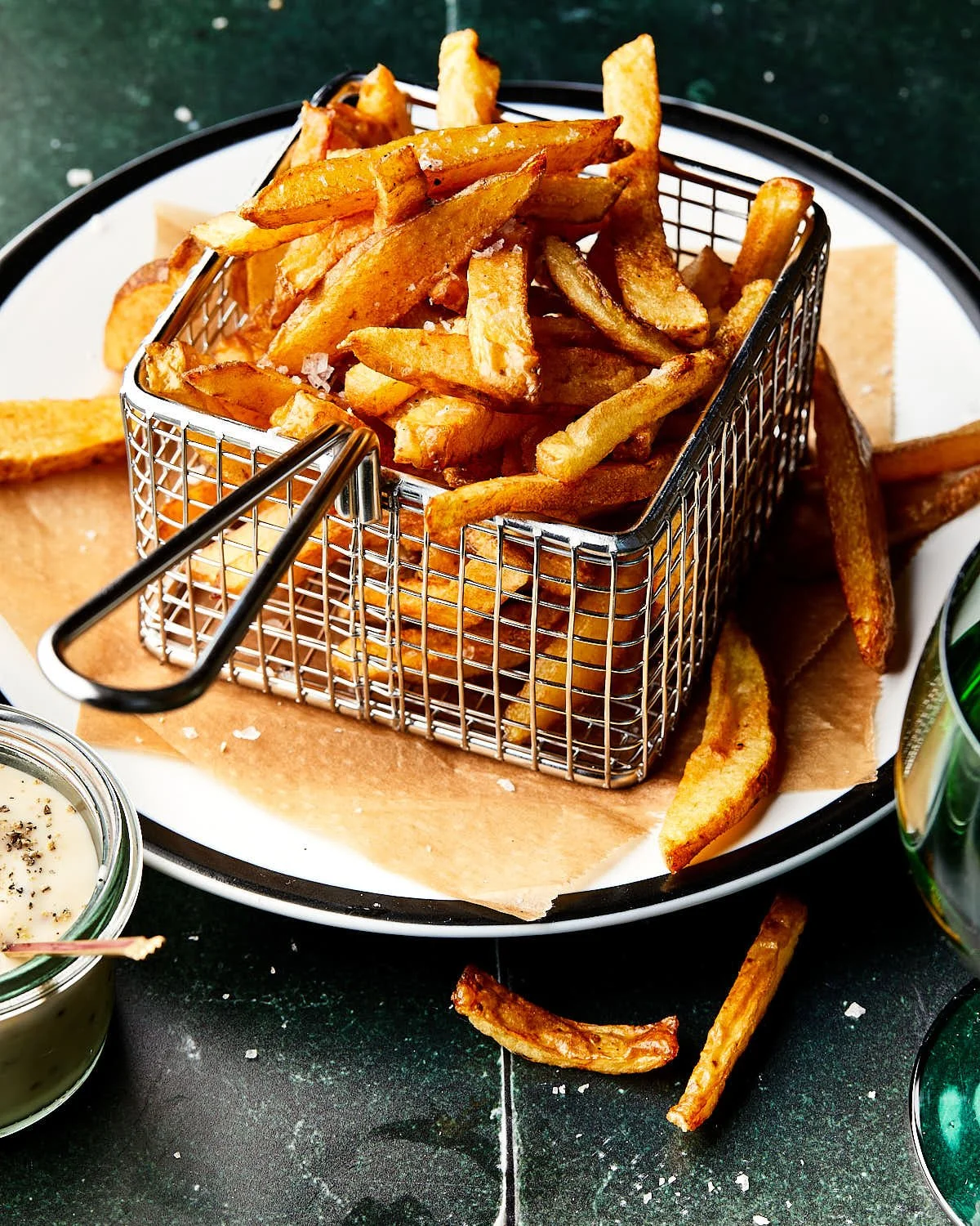 Dunne, huisgemaakte, goudbruine Franse frites met cider-mayonaise gefotografeerd in bistrostyle.