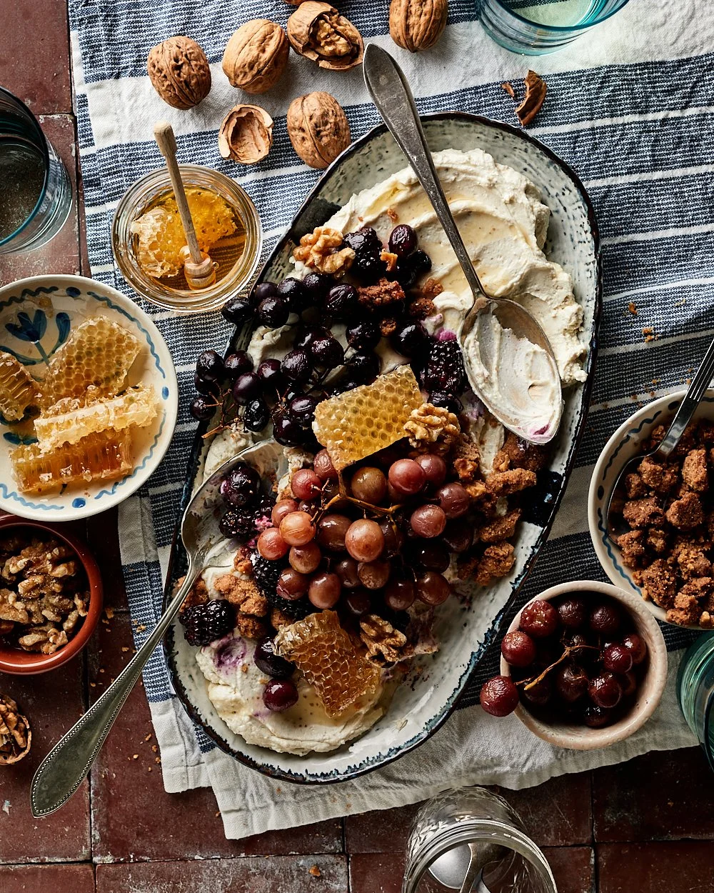 Toetje van hangop van Griekse yoghurt met anijs, geroosterde druiven, bramen en walnoten en een drizzle honing