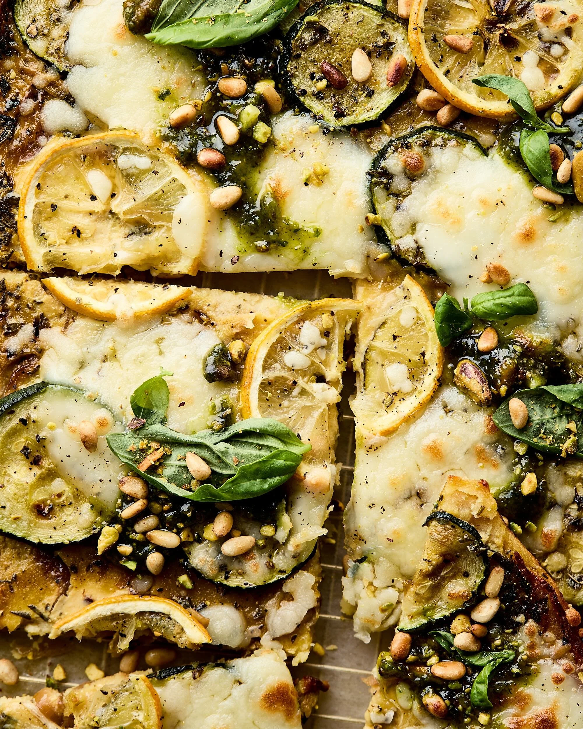 Close up van Farinata met courgette, mozarella, citroen en pesto genovese