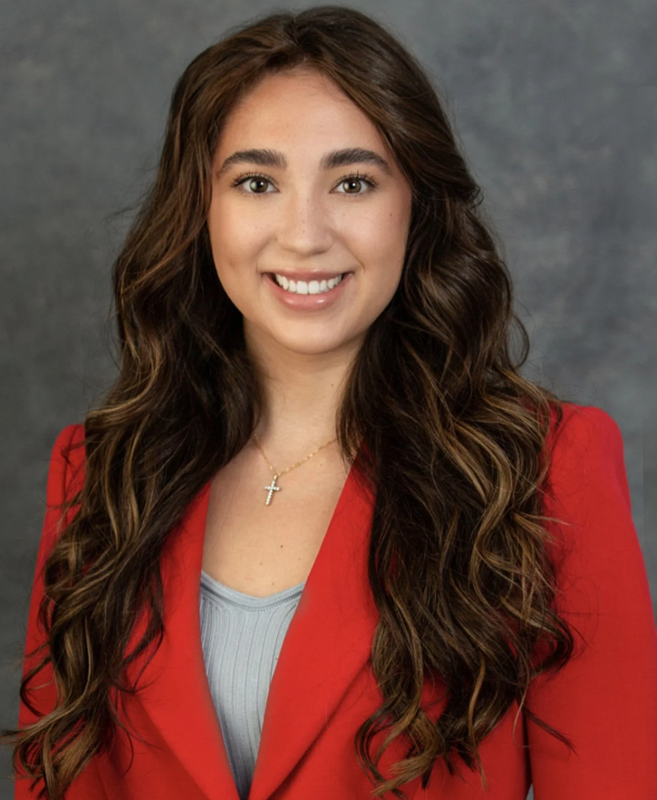 Therapist smiling in photo wearing red blazer.