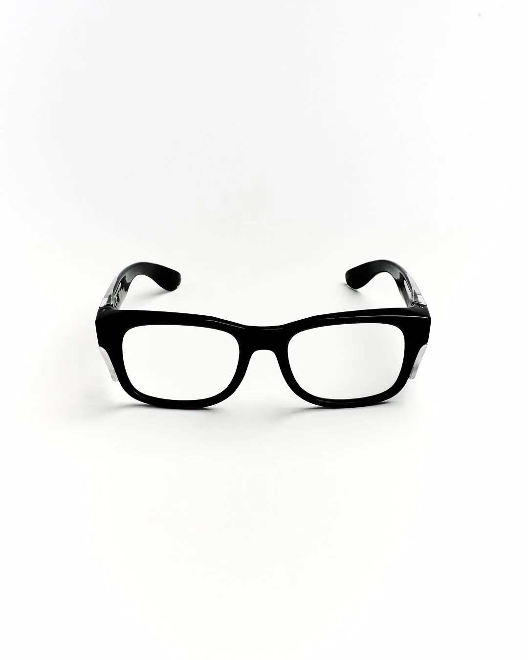 Black eyeglasses with clear lenses on a white background.