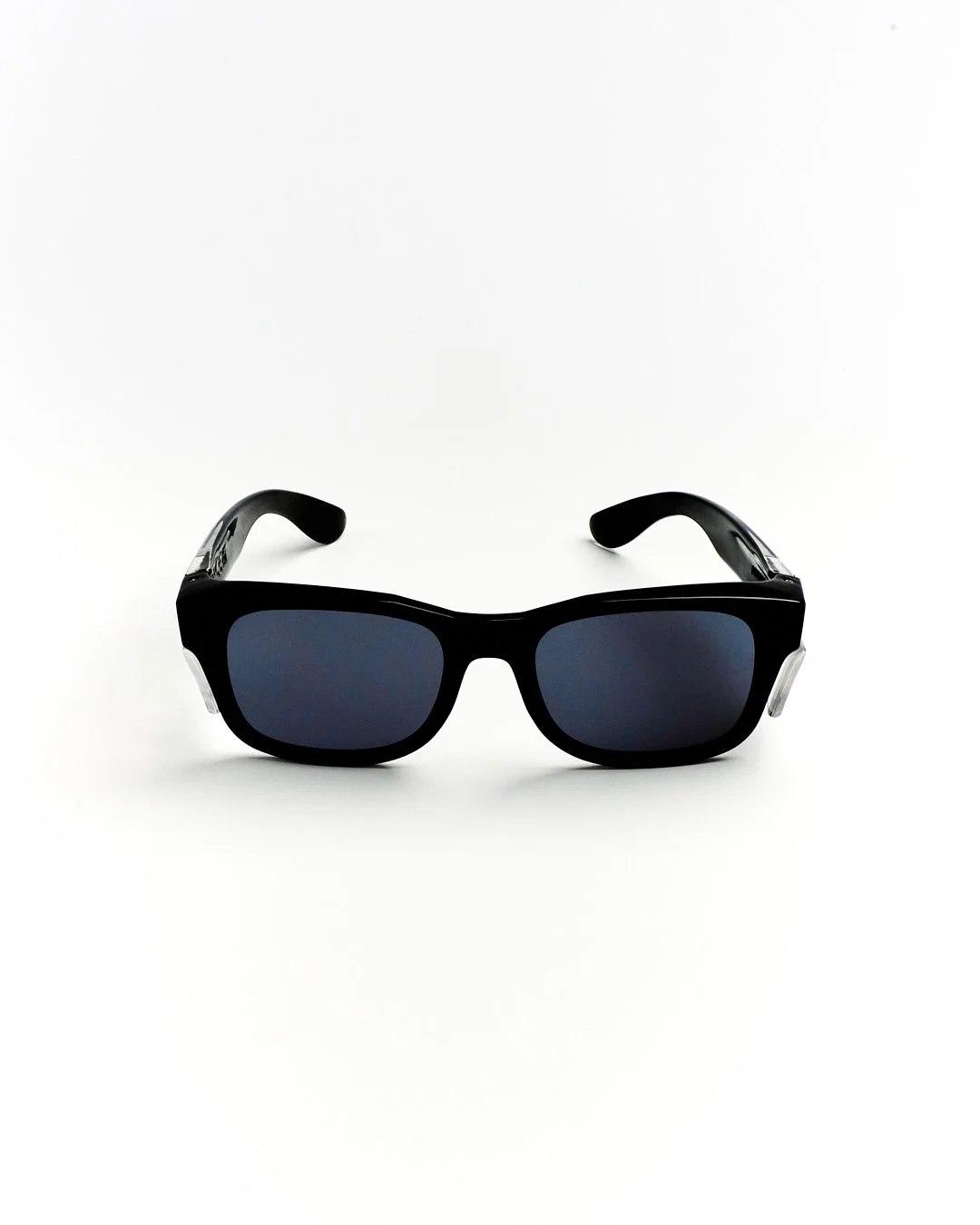 Black sunglasses with dark tinted lenses on a white background.