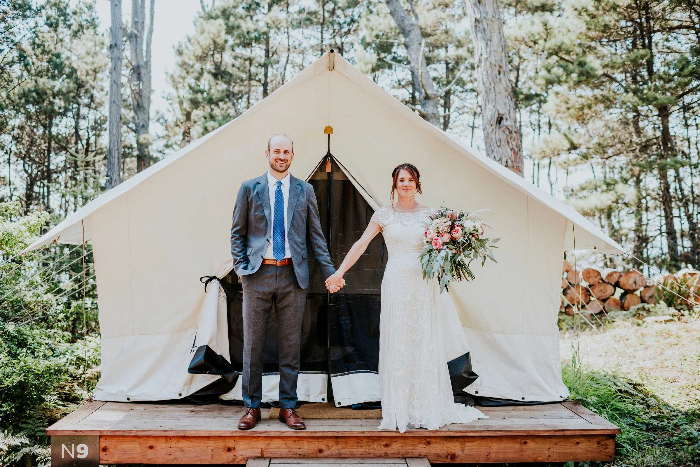  Bride and groom in front of Mendoicno Grove tent at Mendocino Grove wedding reception celebration 