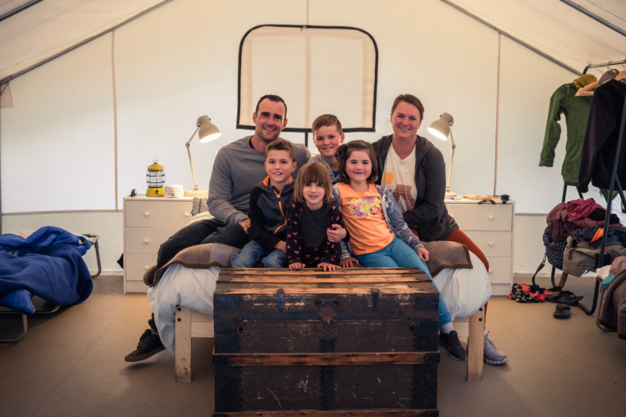 Family relaxing outside a safari-style tent at Mendocino Grove, a family-friendly glamping destination on the Mendocino Coast