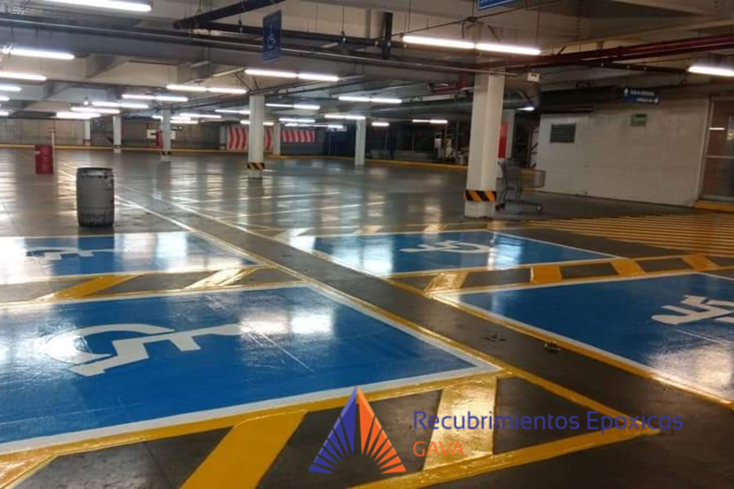 Estacionamiento con áreas designadas para discapacitados y barandillas de seguridad.