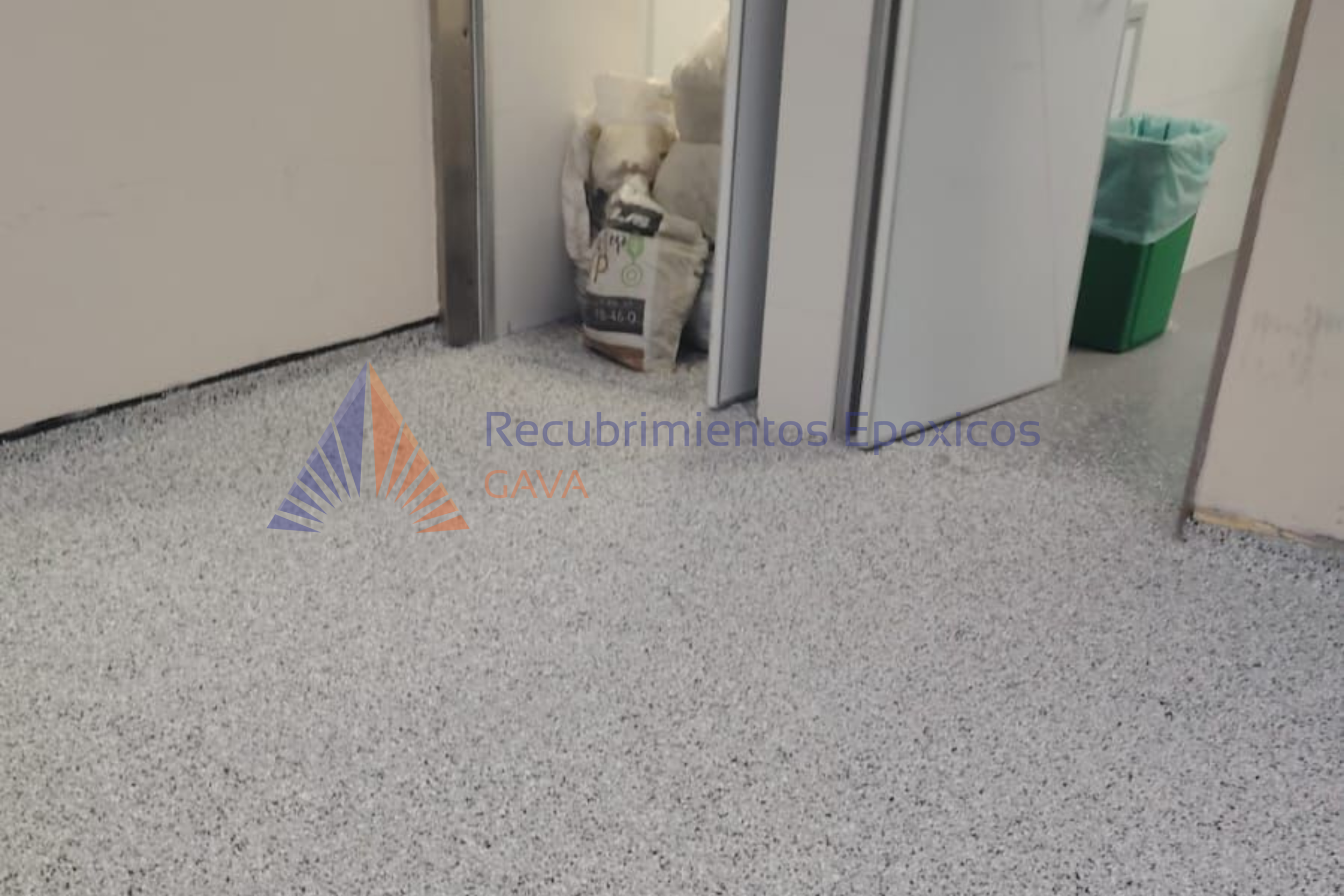 Contenedor de basura y bolsas de empaques de productos en un pasillo de un edificio