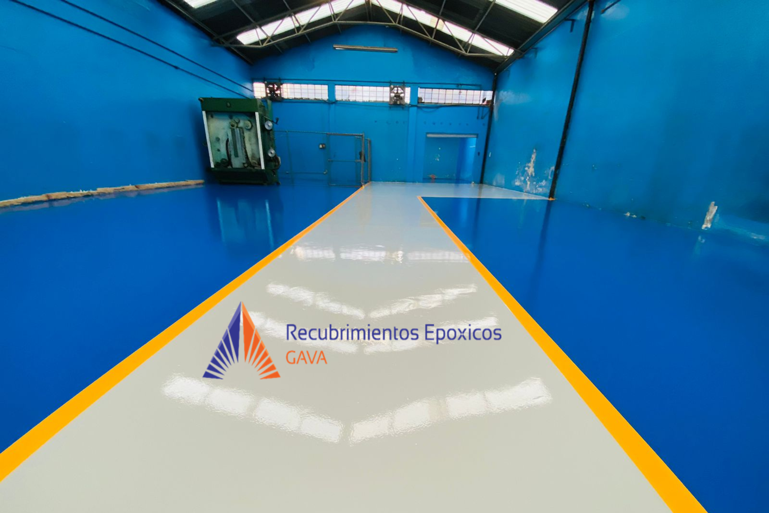Imagen de un espacio de recubrimientos epóxicos con piso de color gris y líneas amarillas, paredes azules y techo con estructura metálica y paneles de vidrio, con un banner en la parte inferior que dice 'Recubrimientos Epóxicos GAVA'.
